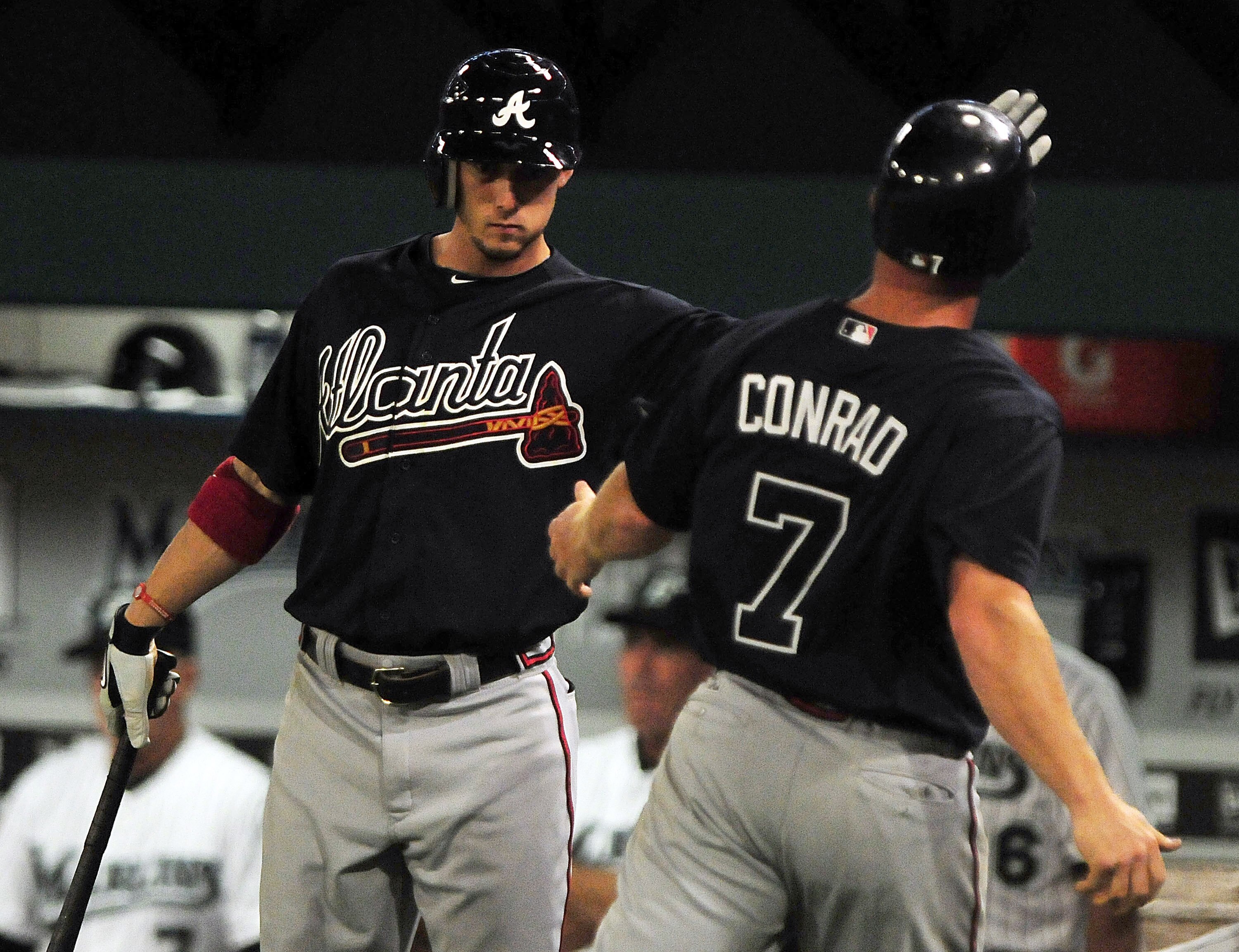 MIAMI GARDENS, FL - JUNE 09:  Brooks Conrad #7 celebrates with Jordan Schafer #1 of the Atlanta Braves after scoring against the Florida Marlins at Sun Life Stadium on June 9, 2011 in Miami Gardens, Florida.  (Photo by Marc Serota/Getty Images)