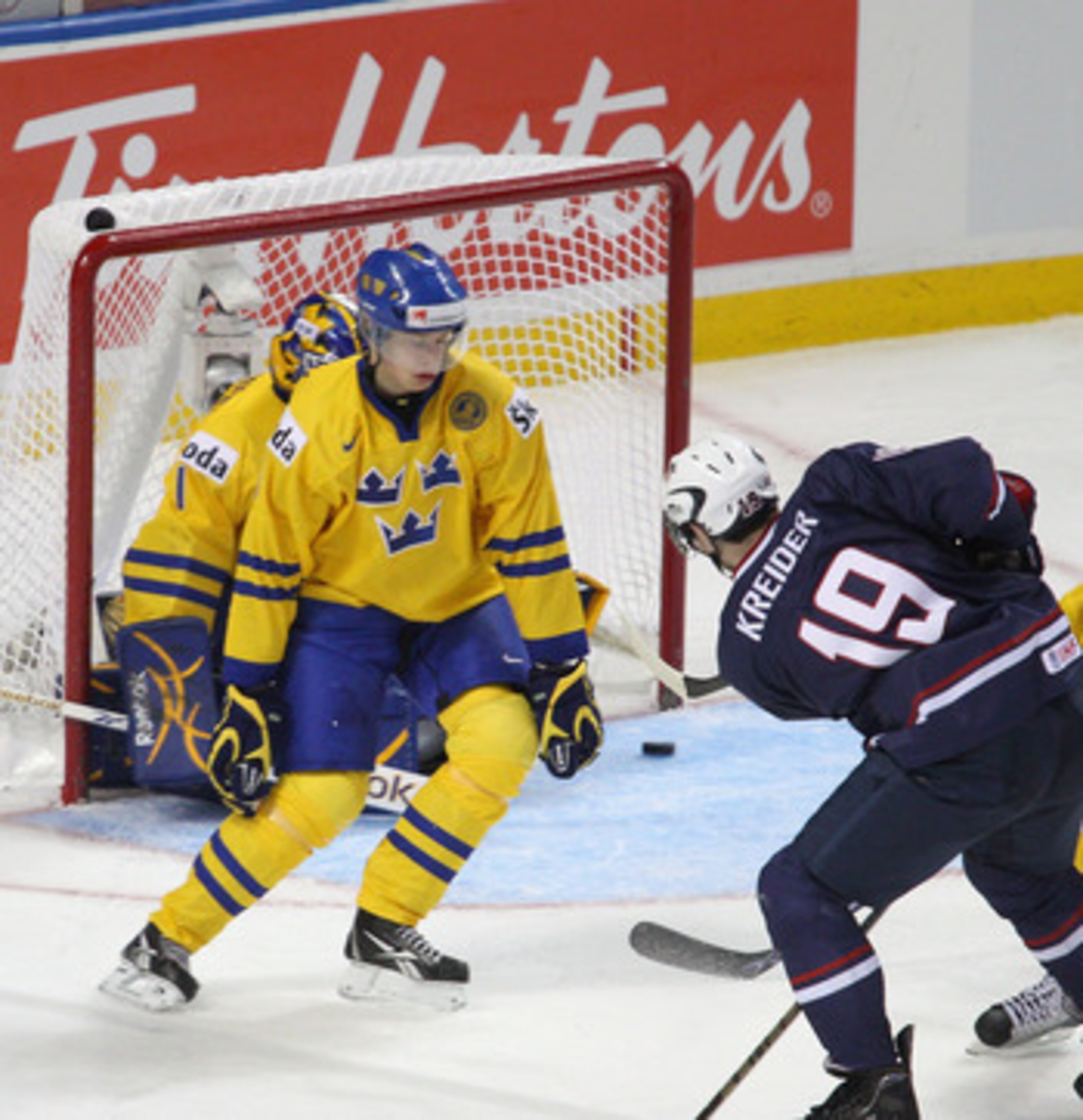 BUFFALO, NY - JANUARY 05: Chris Kreider #19 of the United States slides the puck past Adam Larsson #5 and Fredrik Petersson Wentzel #1 of Sweden for the United States first goal during the 2011 IIHF World U20 Championship Bronze medal game between United