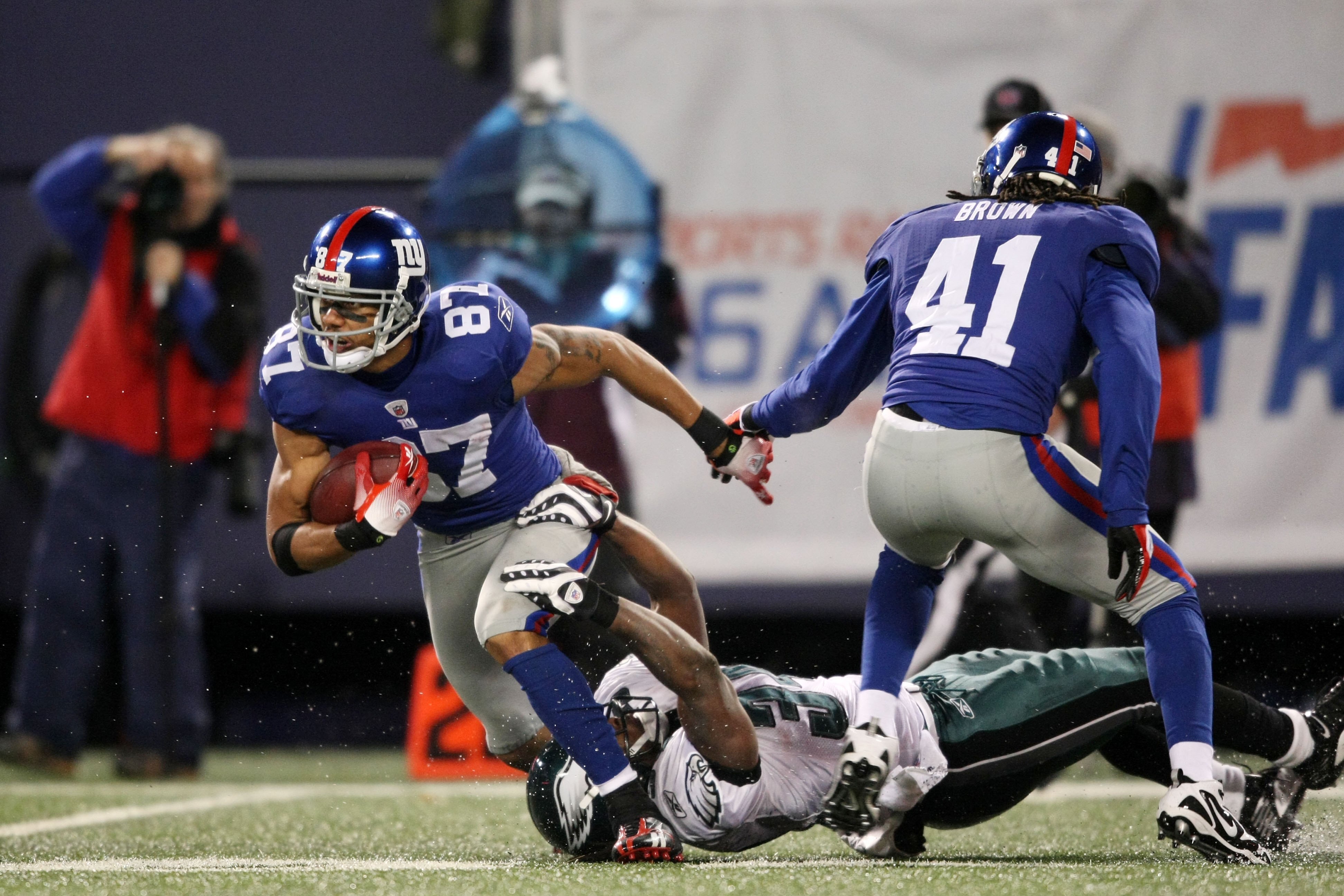 EAST RUTHERFORD, NJ - DECEMBER 13:  Domenik Hixon #87 of the New York Giants runs the ball against Eldra Buckley #34 of the Philadelphia Eagles at Giants Stadium on December 13, 2009 in East Rutherford, New Jersey.  (Photo by Nick Laham/Getty Images)
