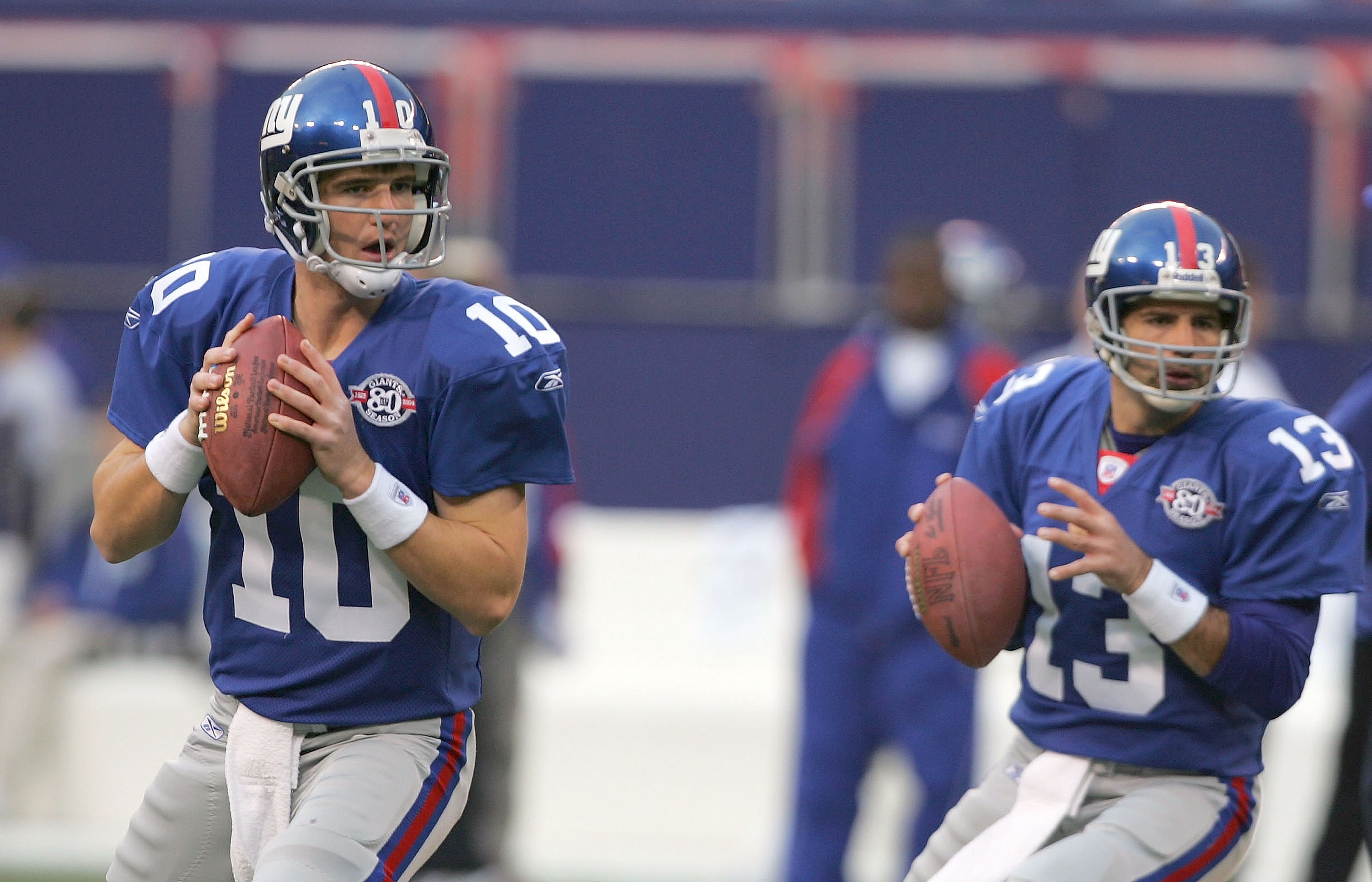 EAST RUTHERFORD, NJ - NOVEMBER 21:  Eli Manning #10 and Kurt Warner #13 of the New York Giants drop back to pass during warm ups before their game against the Atlanta Falcons at Giant Stadium on November 21, 2004 in East Rutherford, New Jersey. (Photo by