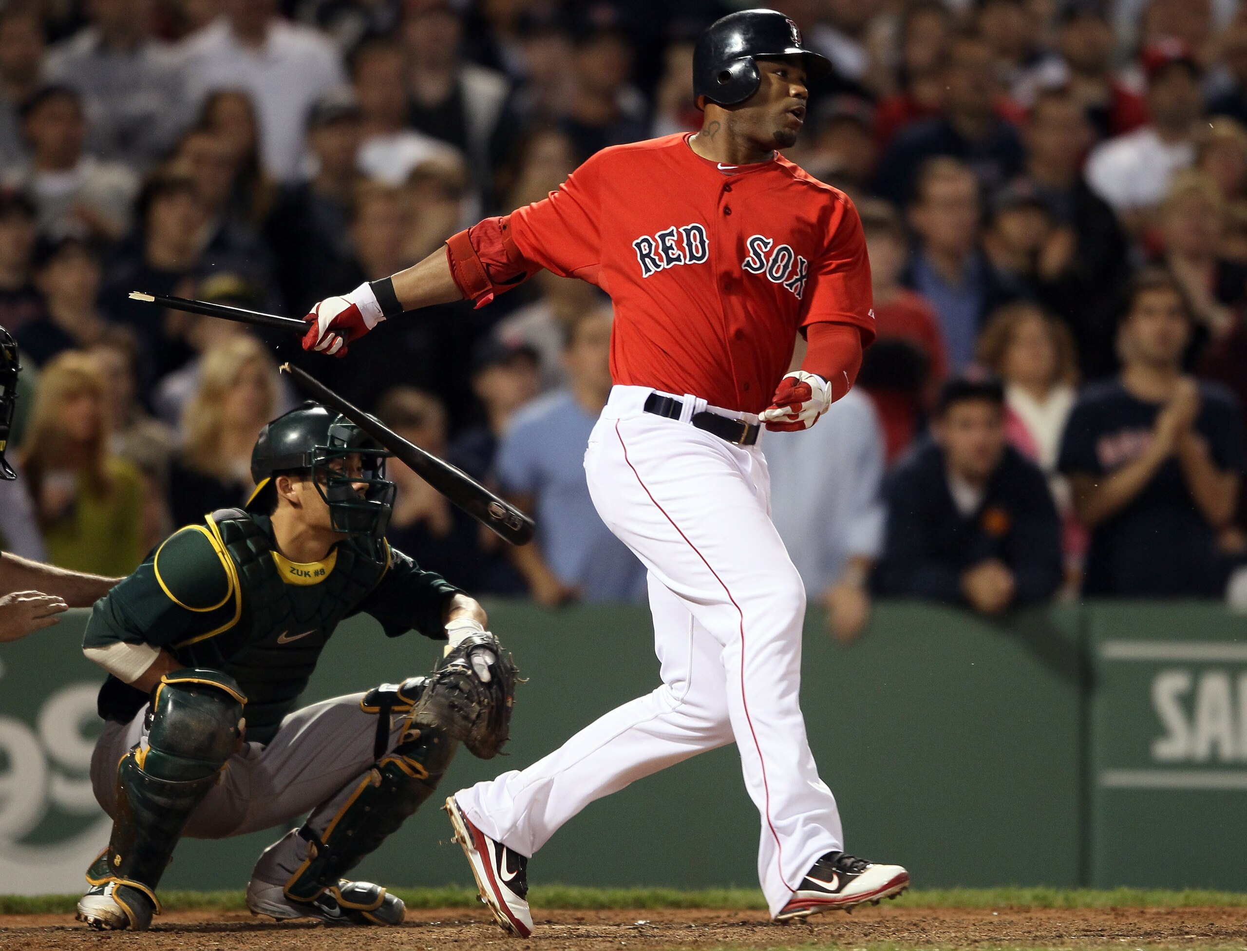 BOSTON, MA - JUNE 03:  Carl Crawford #13 of the Boston Red Sox hits a 2 RBI single in the seventh inning as Kurt Suzuki #8 of the Oakland Athletics defends on June 3, 2011 at Fenway Park in Boston, Massachusetts.  (Photo by Elsa/Getty Images)