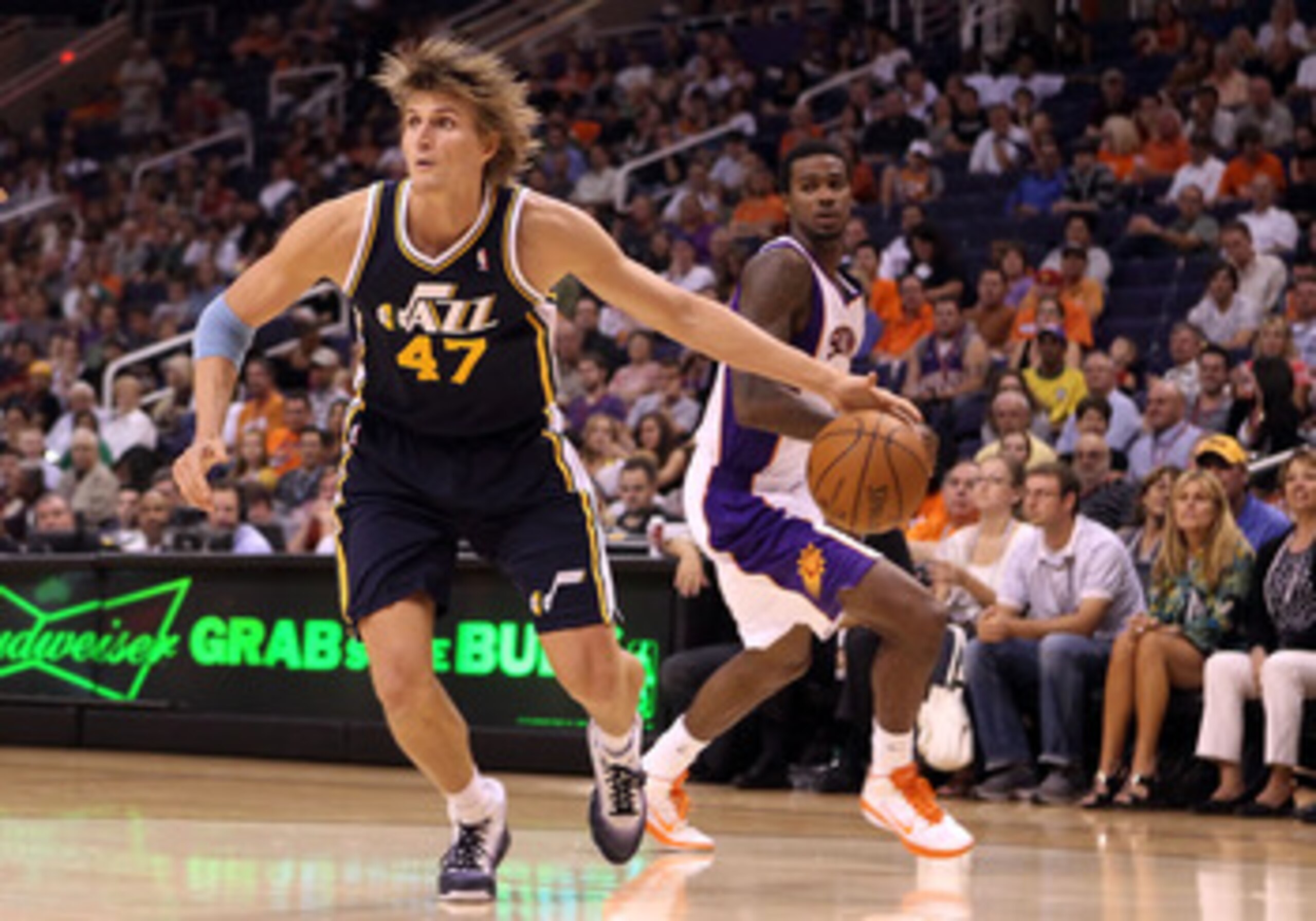 PHOENIX - OCTOBER 12:  Andrei Kirilenko #47 of the Utah Jazz drives the ball past Earl Clark #55 of the Phoenix Suns during the preseason NBA game at US Airways Center on October 12, 2010 in Phoenix, Arizona. NOTE TO USER: User expressly acknowledges and