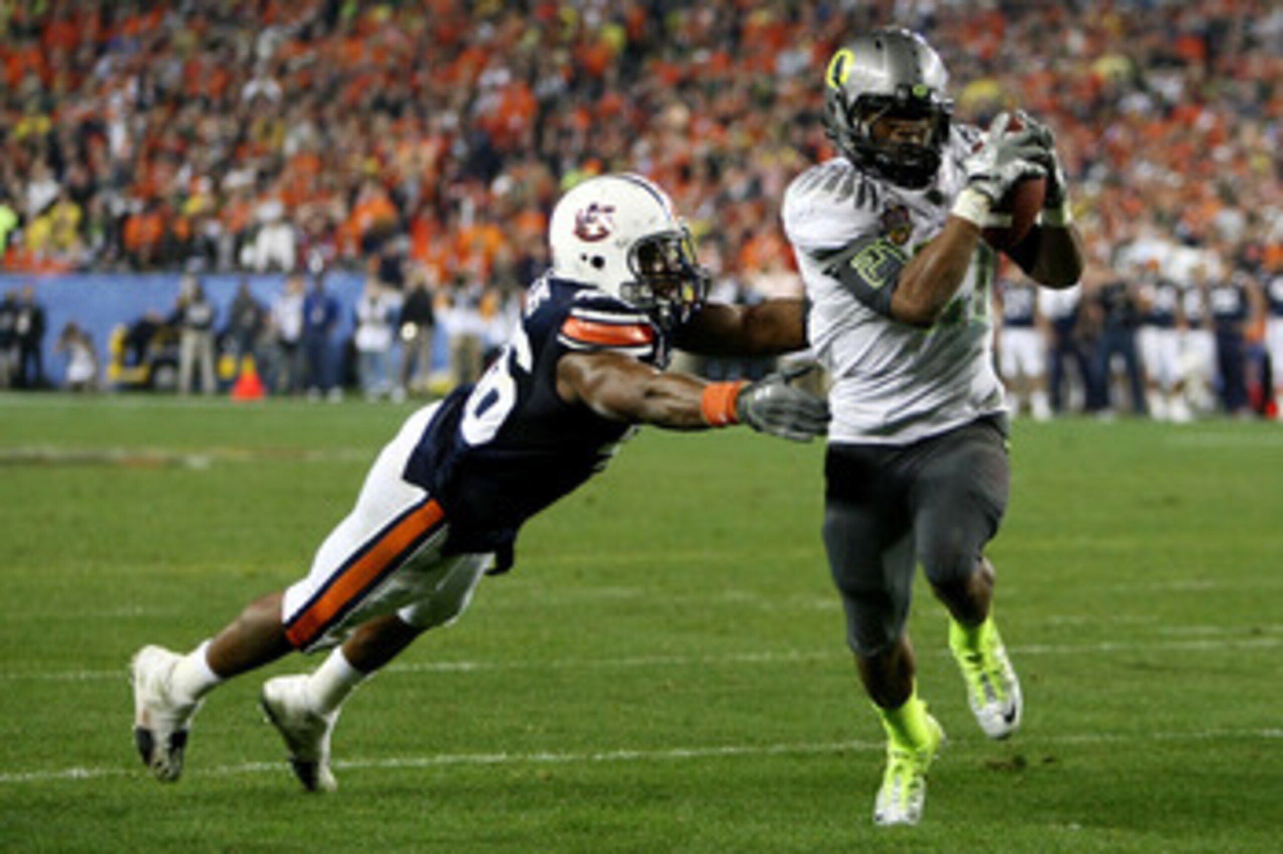 GLENDALE, AZ - JANUARY 10:  Running back LaMichael James #21 of the Oregon Ducks scores a touchdown on a two-yard touchdown reception in front of Craig Stevens #46 of the Auburn Tigers in the fourth quarter during the Tostitos BCS National Championship Ga
