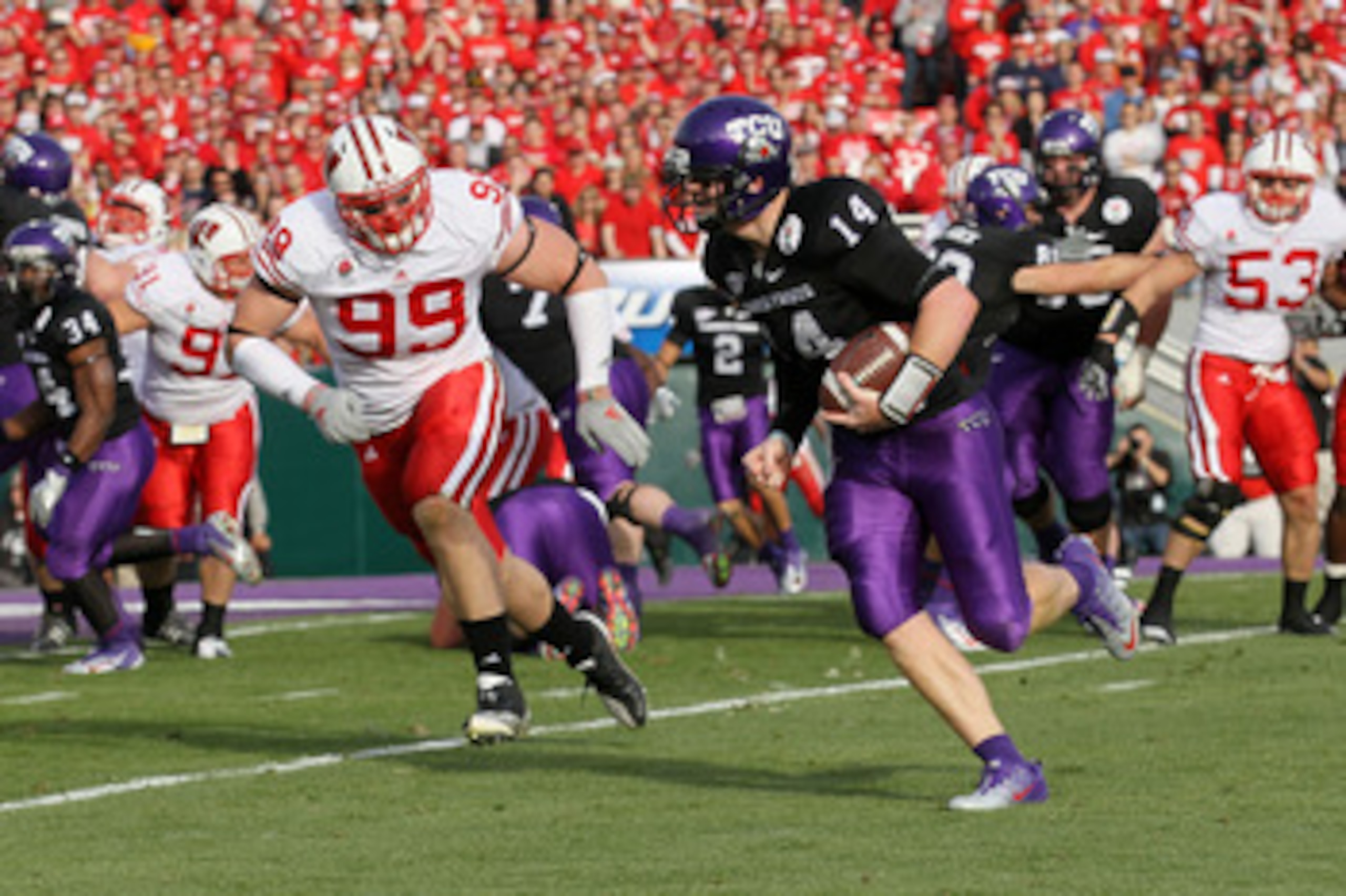 PASADENA, CA - JANUARY 01: Quarterback Andy Dalton #14 of the TCU Horned Frogs rushes with the ball as J.J. Watt #99 of the Wisconsin Badgers runs after him in the first quarter of the 97th Rose Bowl game on January 1, 2011 in Pasadena, California. (Pho PASADENA, CA - JANUARY 01: Quarterback Andy Dalton #14 of the TCU Horned Frogs rushes with the ball as J.J. Watt #99 of the Wisconsin Badgers runs after him in the first quarter of the 97th Rose Bowl game on January 1, 2011 in Pasadena, California. (Pho