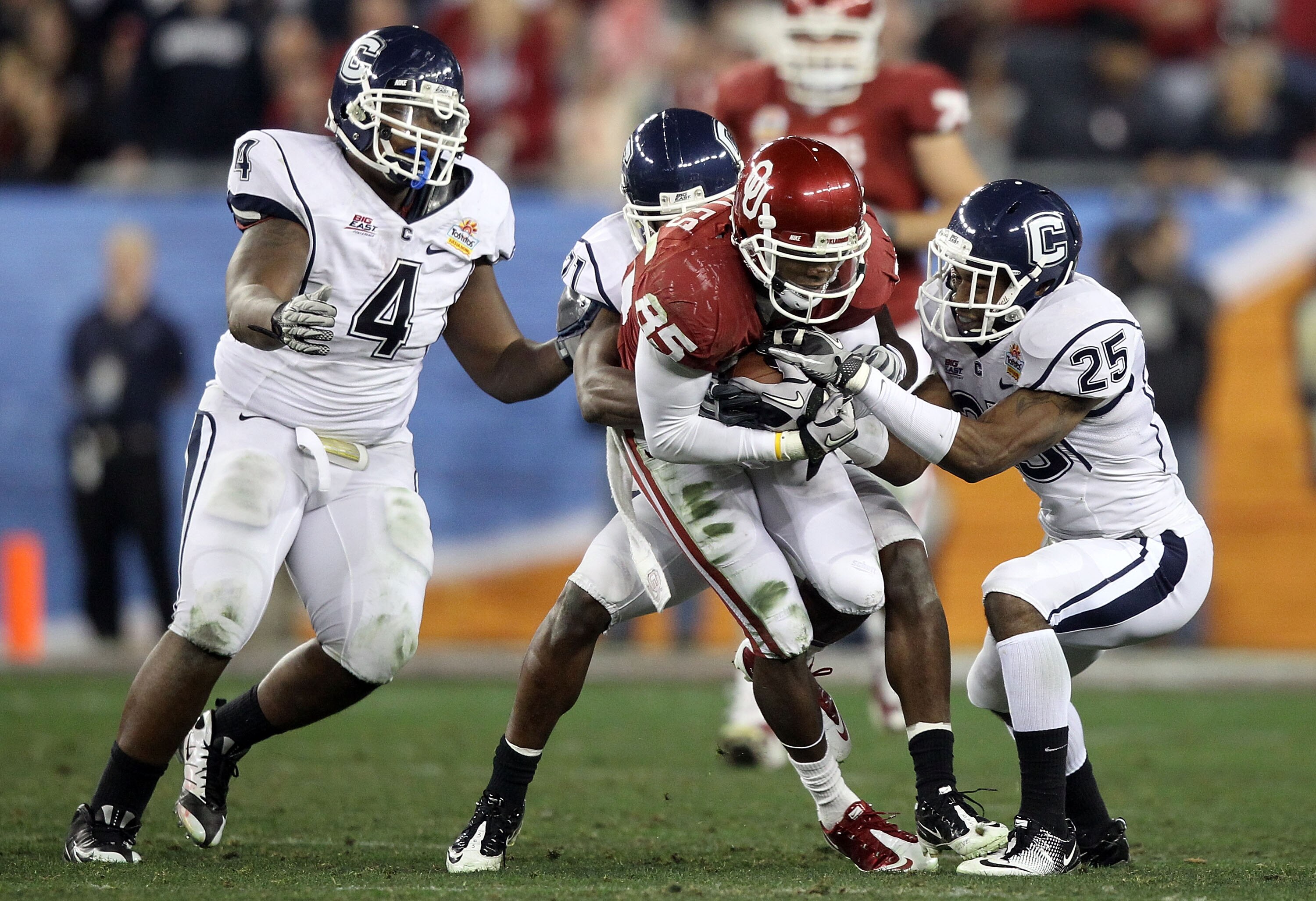 GLENDALE, AZ - JANUARY 01:  Ryan Broyles #85 of the Oklahoma Sooners runs after a catch as Harris Agbor #25 of the Connecticut Huskies attempts to tackle him in the second half during the Tostitos Fiesta Bowl at the Universtity of Phoenix Stadium on Janua
