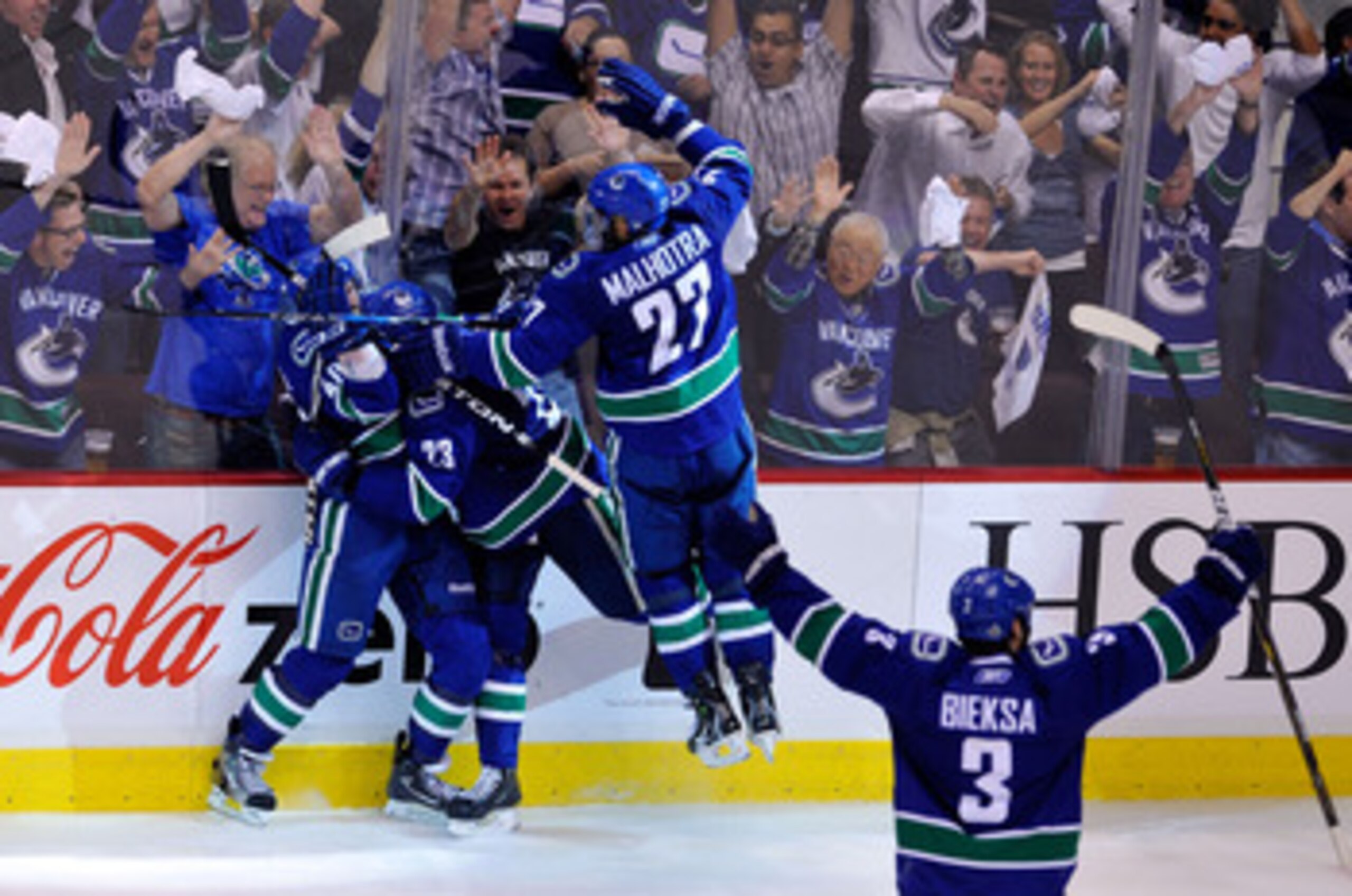 VANCOUVER, BC - JUNE 10:  Maxim Lapierre #40 of the Vancouver Canucks celebrates with Alexander Edler #23, Manny Malhotra #27 and Kevin Bieksa #3 of the Vancouver Canucks after scoring a goal in the third period against the Boston Bruins during Game Five 