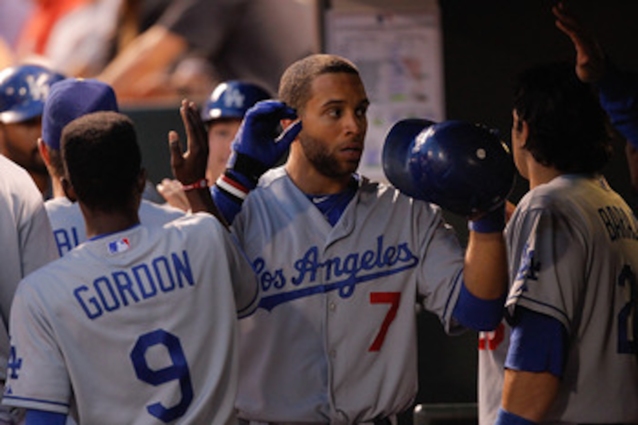 DENVER, CO - JUNE 11: James Loney #7 of the Los Angeles Dodgers is greeted by teammates Dee Strange-Gordon #9 and Rod Barajas #28 in the dugout after scoring in the eighth inning against the Colorado Rockies at Coors Field on June 11, 2011 in Denver, Col DENVER, CO - JUNE 11: James Loney #7 of the Los Angeles Dodgers is greeted by teammates Dee Strange-Gordon #9 and Rod Barajas #28 in the dugout after scoring in the eighth inning against the Colorado Rockies at Coors Field on June 11, 2011 in Denver, Col