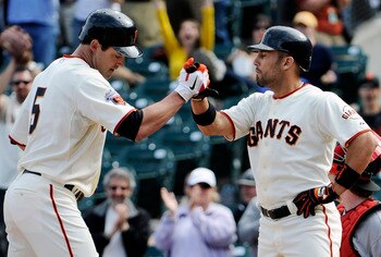 SAN FRANCISCO, CA - JUNE 11: Pat Burrell #5 (L) of the San Francisco Giants is greeted with a high five by teammate Andres Torres #56 (R) after Burrell hit a two run home run in the bottom of the ninth inning against the Cincinnati Reds during a MLB baseb