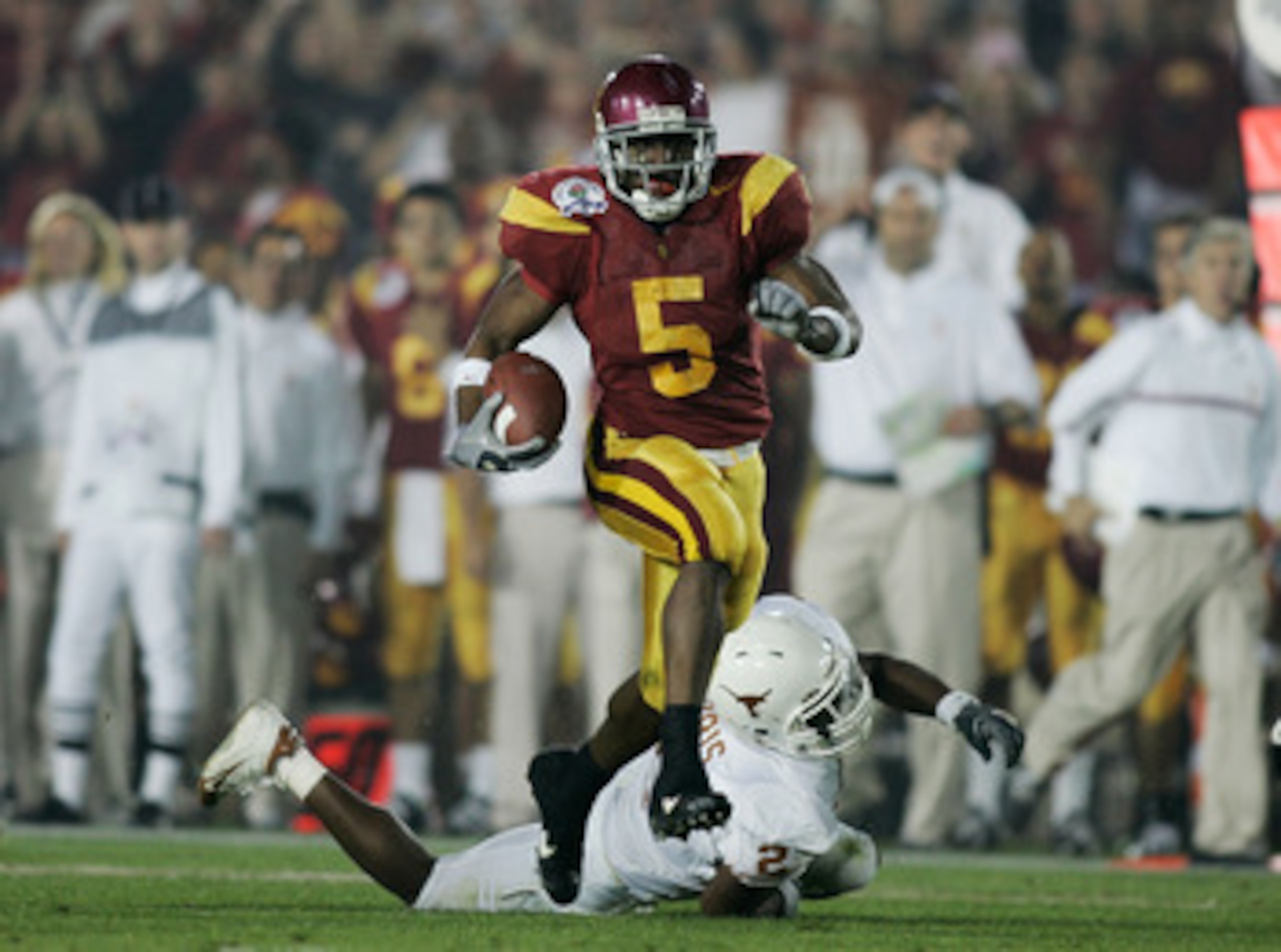 PASADENA, CA - JANUARY 04: Running back Reggie Bush #5 of the USC Trojans carries the football past Aaron Harris #2 of the Texas Longhorns before fumbling the ball on the play in the second quarter during the BCS National Championship Rose Bowl Game on J PASADENA, CA - JANUARY 04: Running back Reggie Bush #5 of the USC Trojans carries the football past Aaron Harris #2 of the Texas Longhorns before fumbling the ball on the play in the second quarter during the BCS National Championship Rose Bowl Game on J