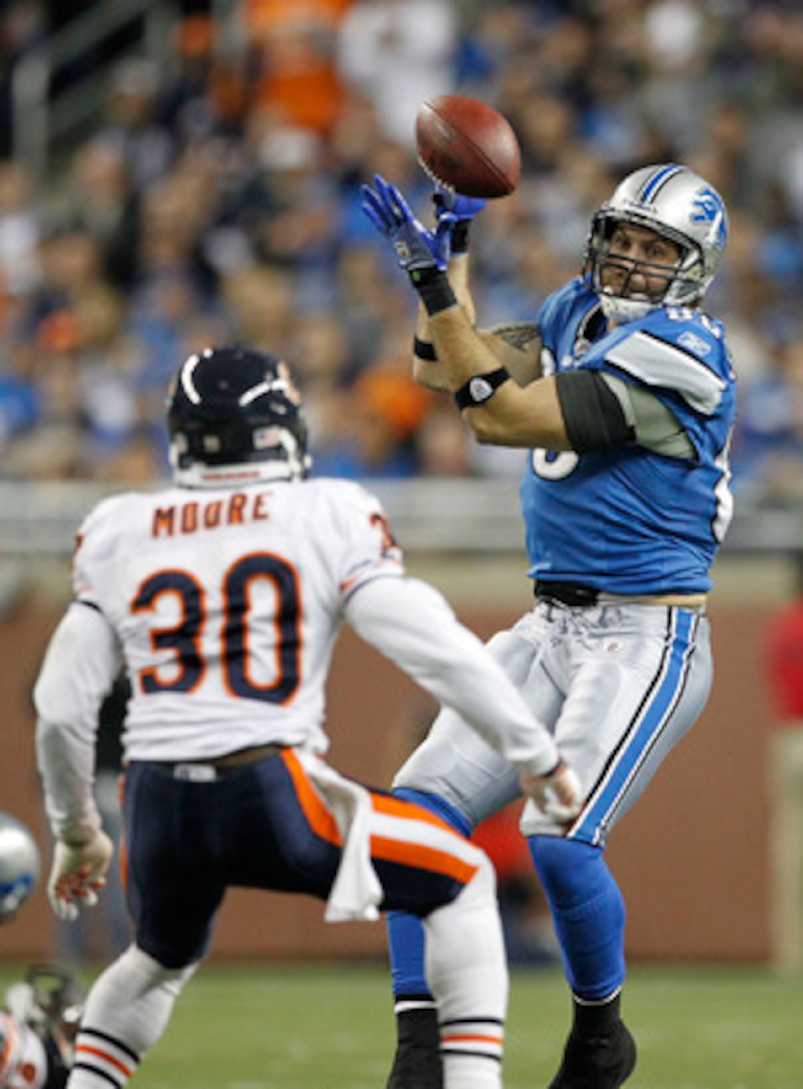 DETROIT - DECEMBER 05: Tony Scheffler #85 of the Detroit Lions makes a catch as D. J. Moore #30 of the Chicago Bears defends during the fourth quarter of the game at Ford Field on December 5, 2010 in Detroit, Michigan. The Bears defeated the Lions 24-20.