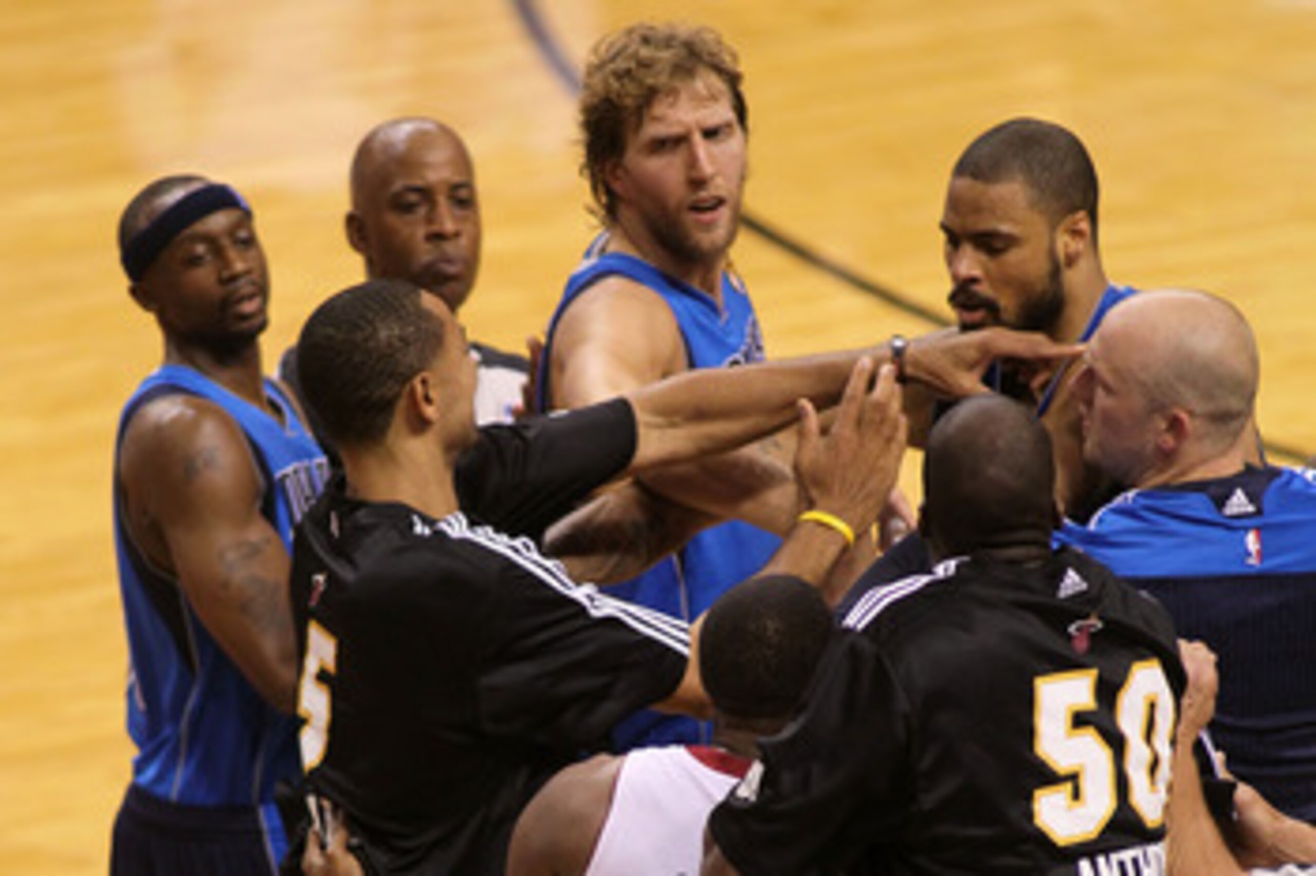 MIAMI, FL - JUNE 12:  Jason Terry #31 (L), Dirk Nowitzki (C) #41 and Brian Cardinal (R) #35 of the Dallas Mavericks attempt to seperate teammate Tyson Chandler (R) #6 of the Dallas Mavericks and Juwan Howard #5 of the Miami Heat on the court in the second