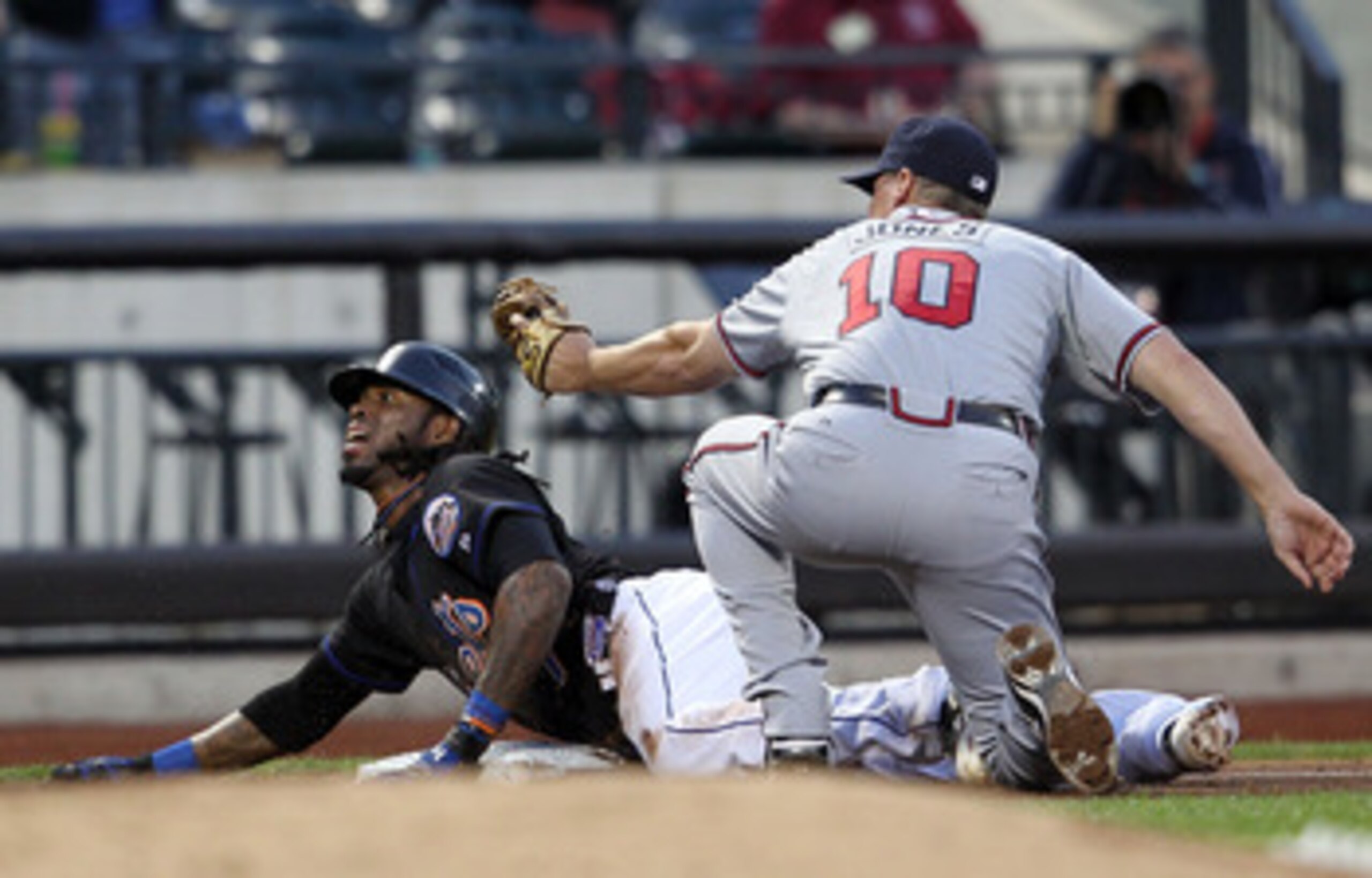 NEW YORK, NY - JUNE 03:  Jose Reyes #7 of the New York Mets safely slides in to third on a triple under the tag of Chipper Jones #10 of the Atlanta Braves at Citi Field on June 3, 2011 in the Flushing neighborhood of the Queens borough of New York City.  