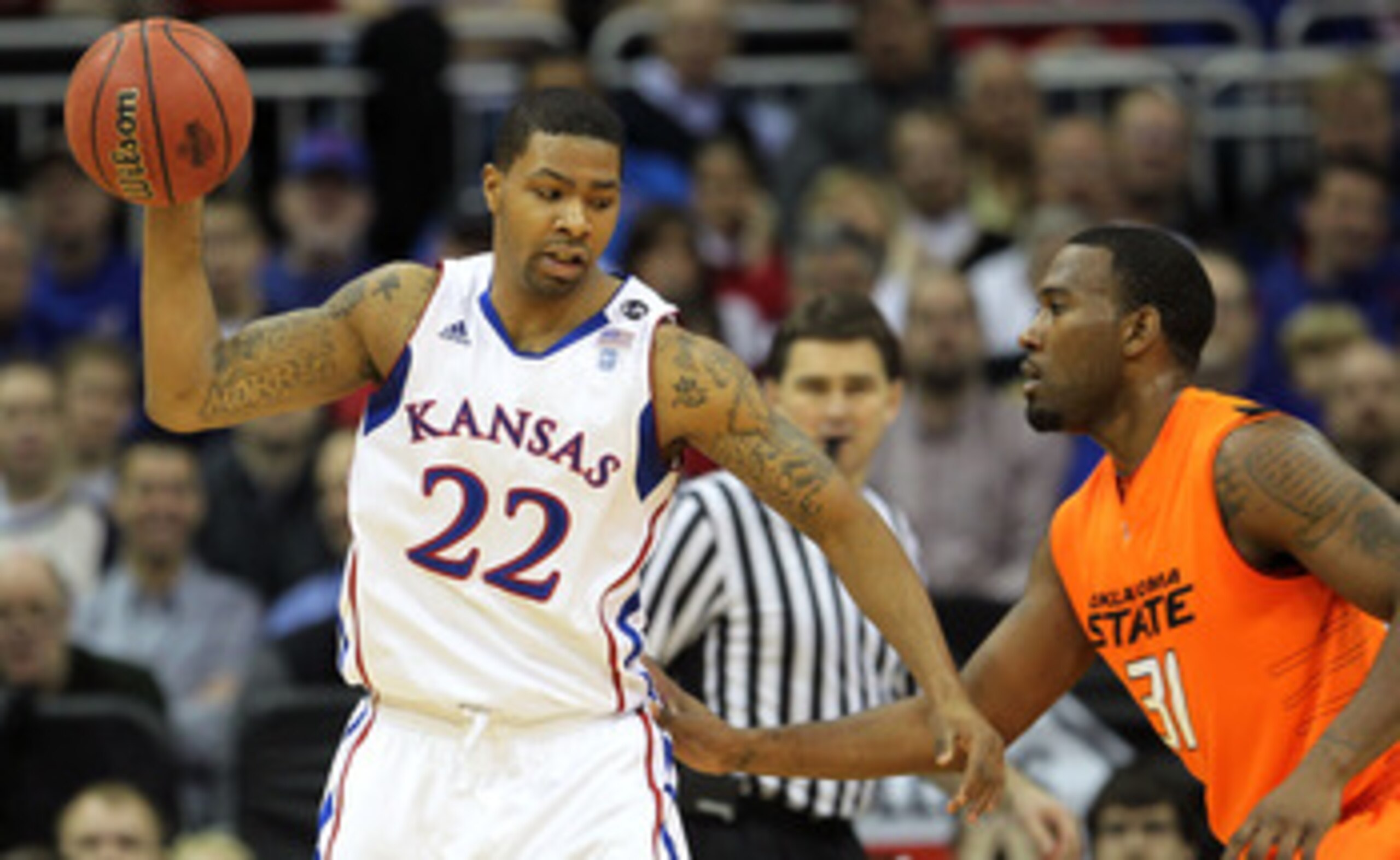 KANSAS CITY, MO - MARCH 10:  Marcus Morris #22 of the Kansas Jayhawks looks to move the ball against Matt Pilgrim #31 of the Oklahoma State Cowboys during their quarterfinal game in the 2011 Phillips 66 Big 12 Men's Basketball Tournament at Sprint Center 