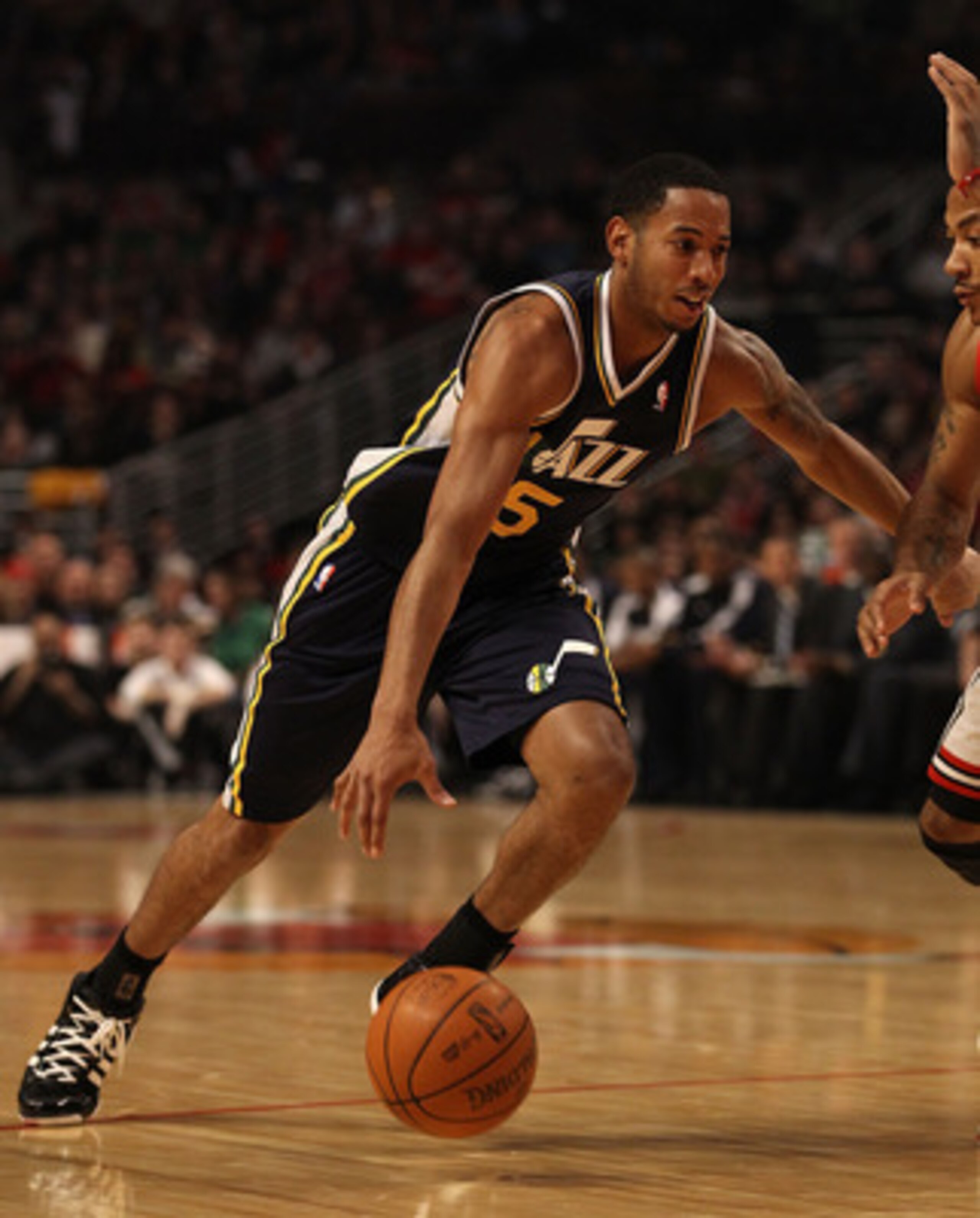 CHICAGO, IL - MARCH 12: Devin Harris #5 of the Utah Jazz drives against Derrick Rose #1 of the Chicago Bulls at the United Center on March 12, 2011 in Chicago, Illinois. The Bulls defeated the Jazz 118-100. NOTE TO USER: User expressly acknowledges and ag