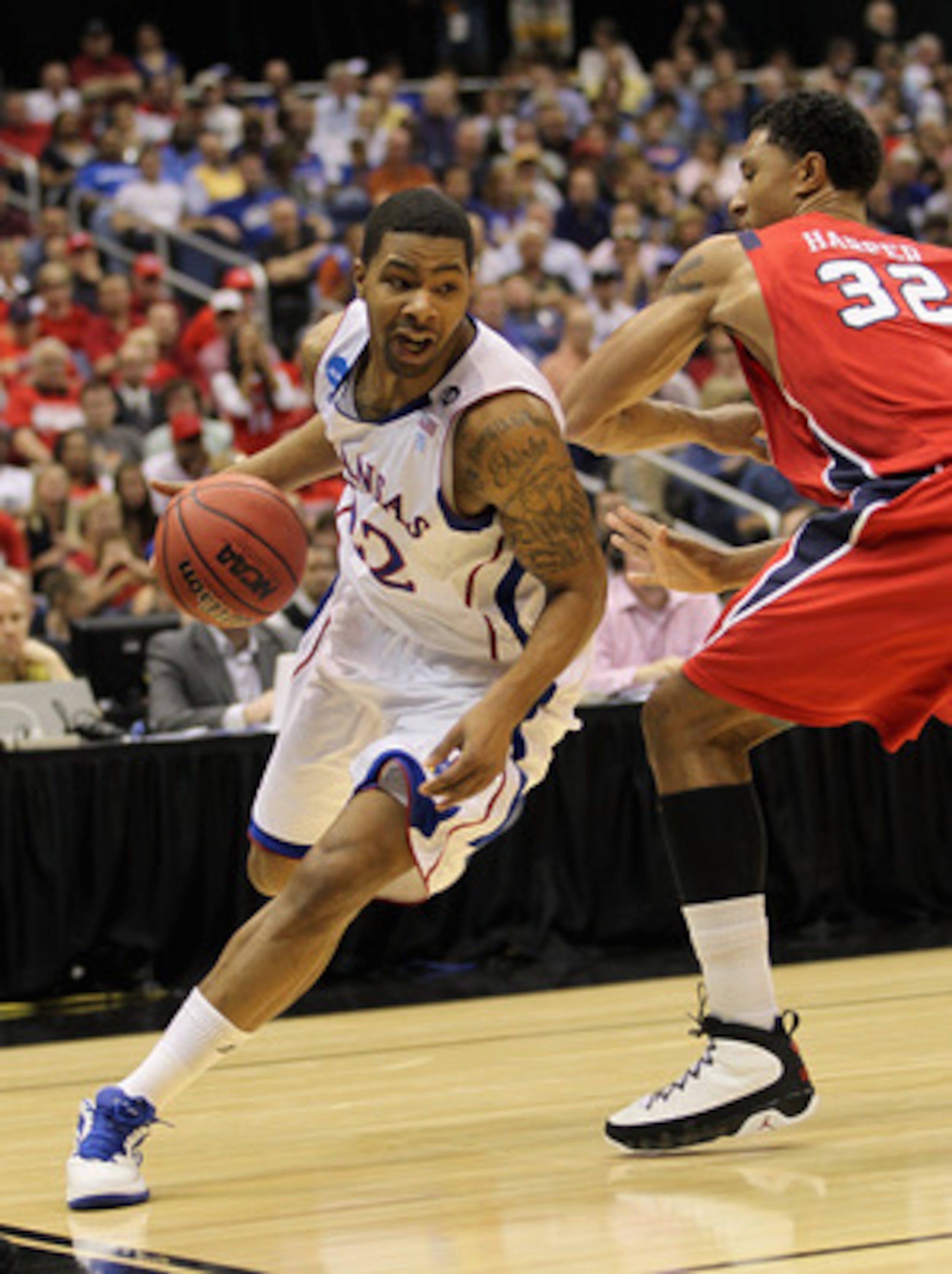SAN ANTONIO, TX - MARCH 25:  Marcus Morris #22 of the Kansas Jayhawks drives against Justin Harper #32 of the Richmond Spiders during the southwest regional of the 2011 NCAA men's basketball tournament at the Alamodome on March 25, 2011 in San Antonio, Te