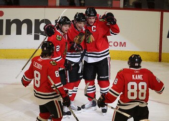 CHICAGO, IL - MARCH 02: (L-R) Nick Leddy #8, Duncan Keith #2, Patrick Sharp #10 and Jonathan Toews #19 of the Chicago Blackhawks welcome teammate Patrick Kane #88 to celebrate Toew's goal against the Calgary Flames at the United Center on March 2, 2011 in