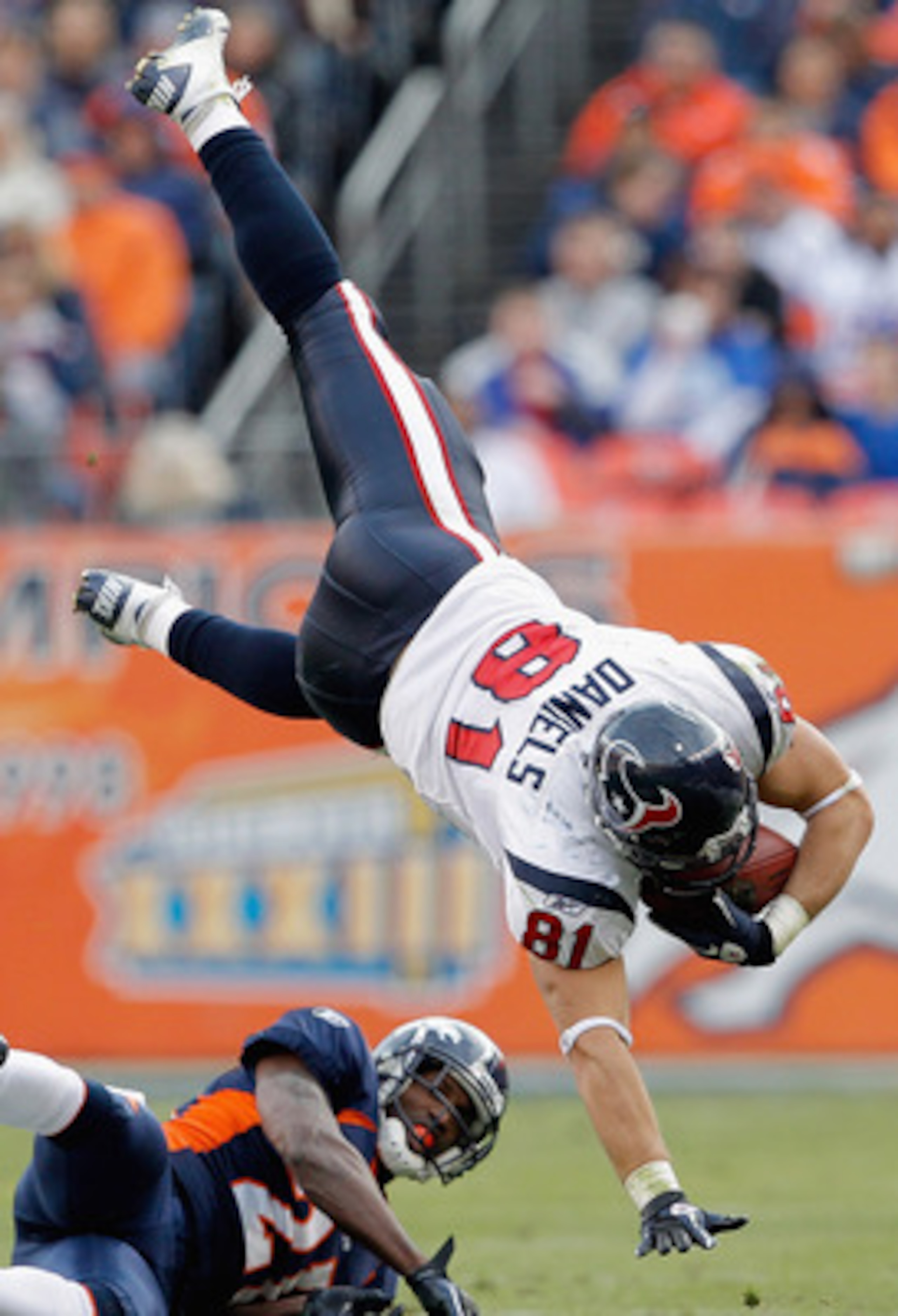 DENVER - DECEMBER 26: Owen Daniels #81 of the Houston Texans gets up-ended by Andre' Goodman #21 of the Denver Broncos during the first quarter at INVESCO Field at Mile High on December 26, 2010 in Denver, Colorado. (Photo by Justin Edmonds/Getty Images)