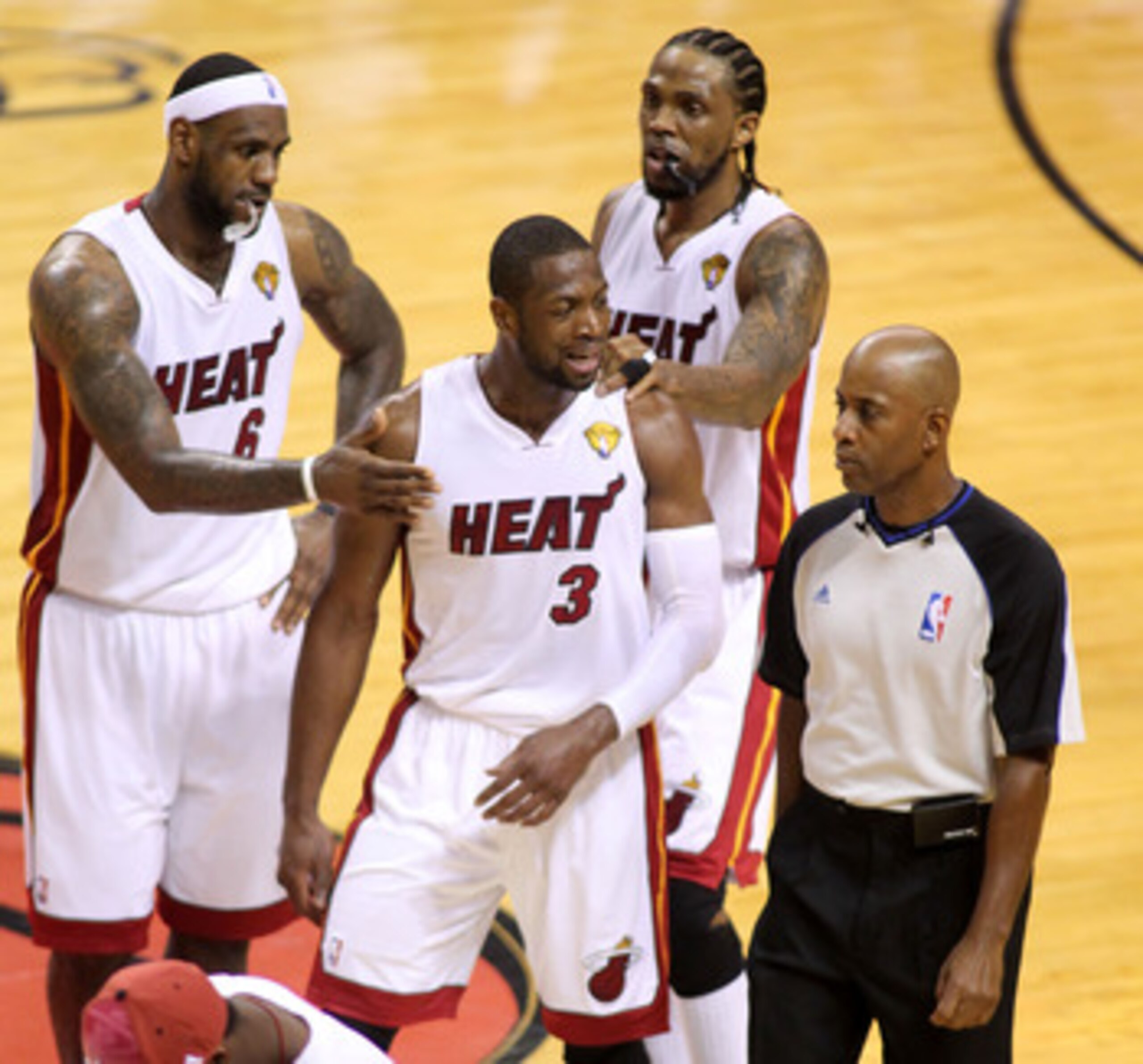 MIAMI, FL - JUNE 12:  Dwyane Wade #3 of the Miami Heat is held back by teammates LeBron James #6 and Udonis Haslem #40 as wade argues with referee Derrick Stafford #9 against the Dallas Mavericks in the the second half of Game Six of the 2011 NBA Finals a