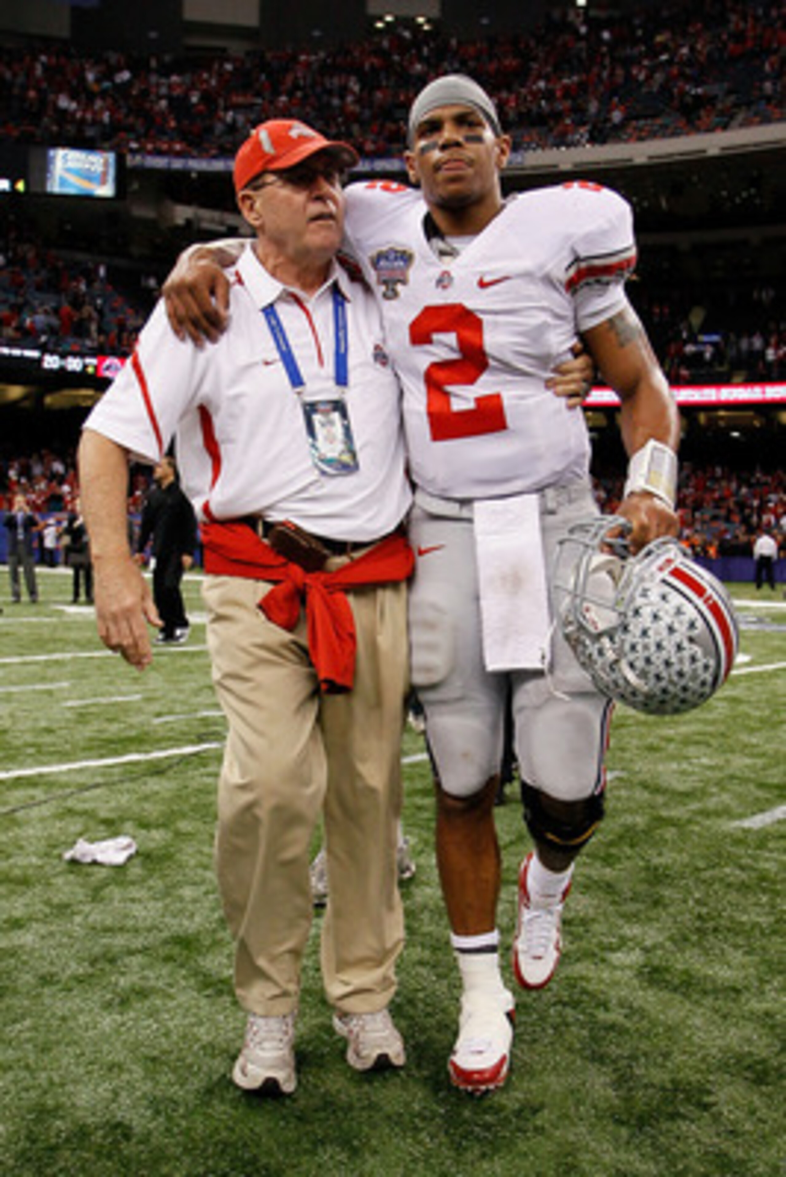 NEW ORLEANS, LA - JANUARY 04:  (M) Quarterback Terrelle Pryor #2 of the Ohio State Buckeyes is helped off the field by a member of the Buckeyes support team after the Buckeyes 31-26 victory against the Arkansas Razorbacks during the Allstate Sugar Bowl at