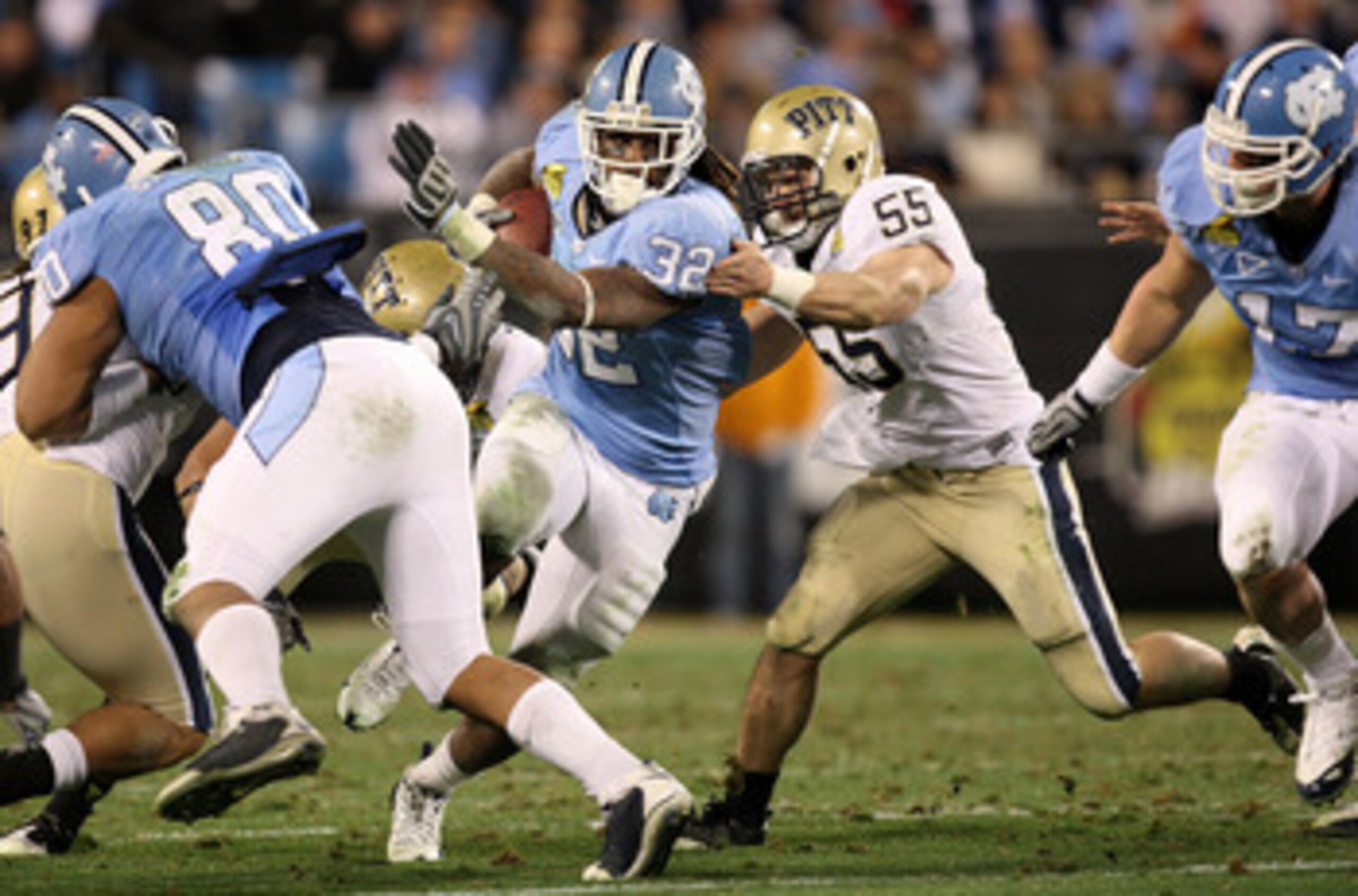 CHARLOTTE, NC - DECEMBER 26:  Max Gruder #55 of the Pittsburgh Panthers tackles Ryan Houston #32 of the North Carolina Tar Heels during their game on December 26, 2009 in Charlotte, North Carolina.  (Photo by Streeter Lecka/Getty Images)