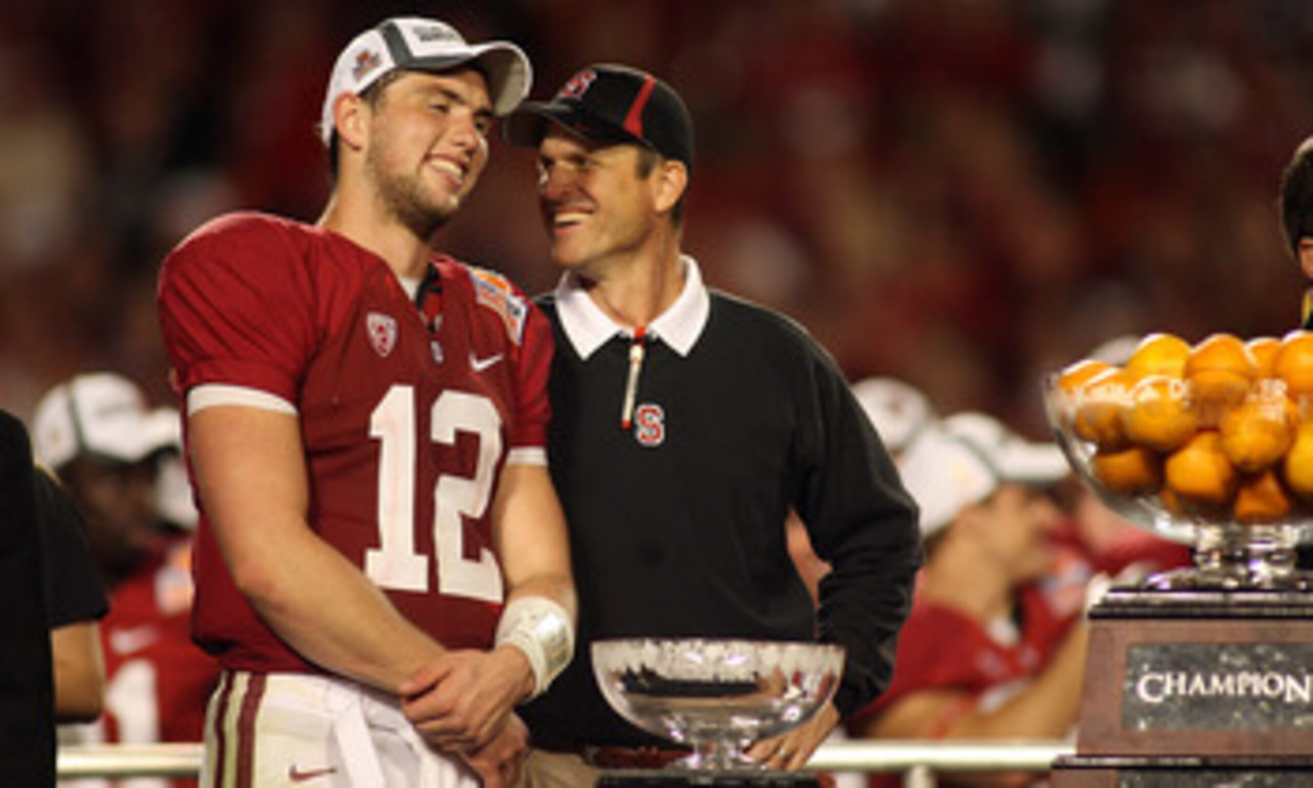 MIAMI, FL - JANUARY 03: (L-R) Quarterback Andrew Luck #12 and head coach Jim Harbaugh of the Stanford Cardinal celebrate with the trophy on stage after Stanford won 40-12 against the Virginia Tech Hokies during the 2011 Discover Orange Bowl at Sun Life St