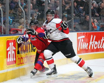 TORONTO, CANADA - JANUARY 19:  Ty Rattie #8  of Team Cherry is hammered by  Brandon Saad #22 of Team Orr in the 2011 Home Hardware Top Prospects game on January 19, 2011 at the Air Canada Centre in Toronto, Canada. Team Orr defeated Team Cherry 7-1. (Phot
