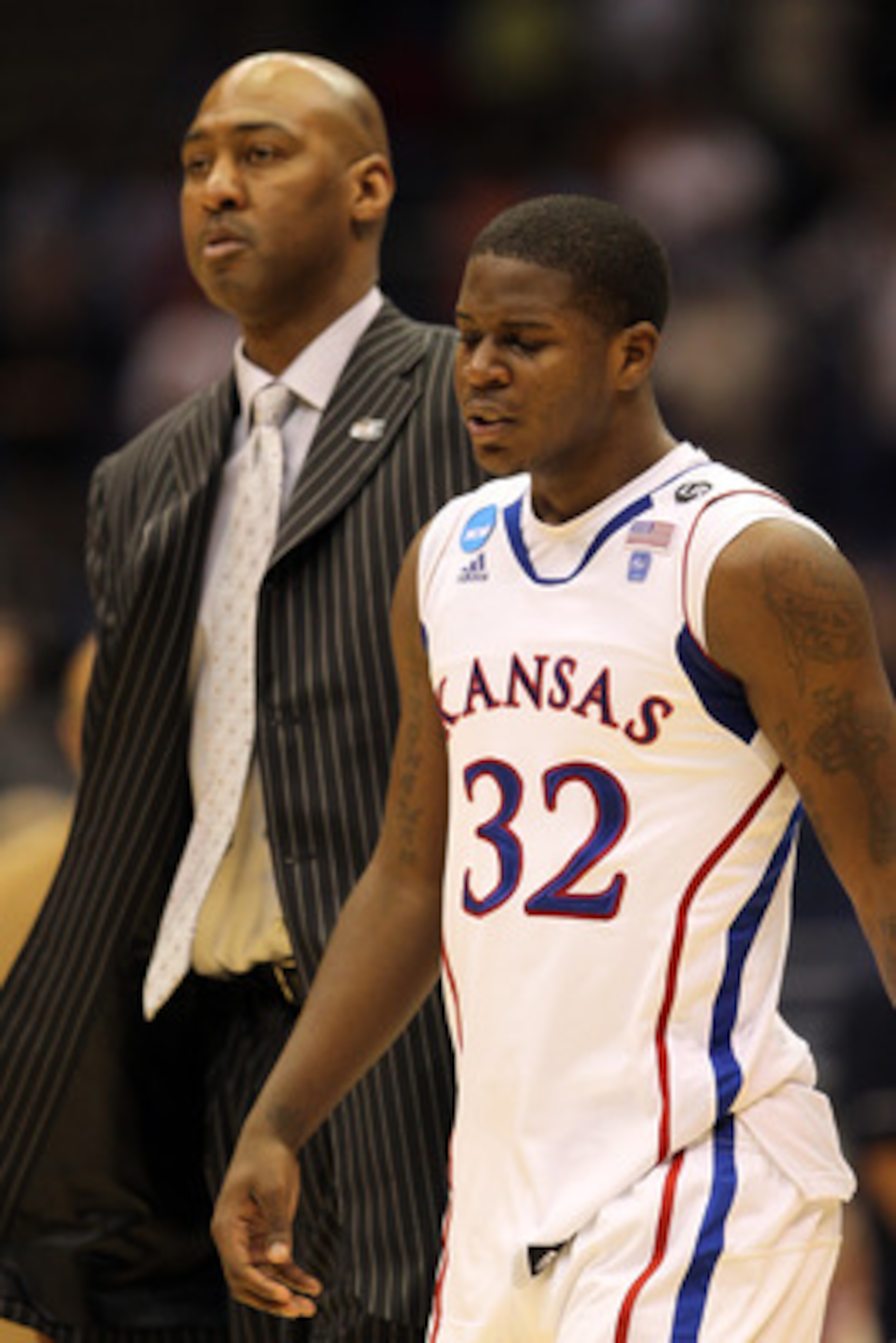 SAN ANTONIO, TX - MARCH 27:  Josh Selby #32 of the Kansas Jayhawks and assistant coach Danny Manning react after the southwest regional final of the 2011 NCAA men's basketball tournament against the Virginia Commonwealth Rams at the Alamodome on March 27,