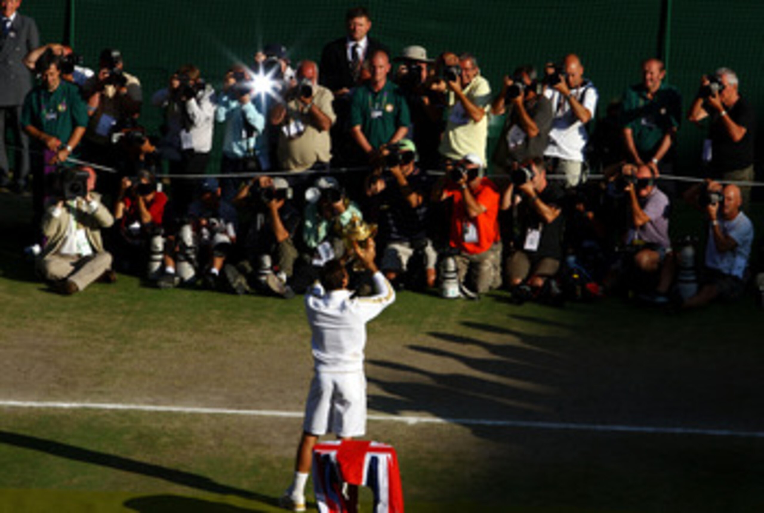 WIMBLEDON, ENGLAND - JULY 05:  Roger Federer of Switzerland poses for photographers as he celebrates victory with the trophy after the men's singles final match against Andy Roddick of USA on Day Thirteen of the Wimbledon Lawn Tennis Championships at the 