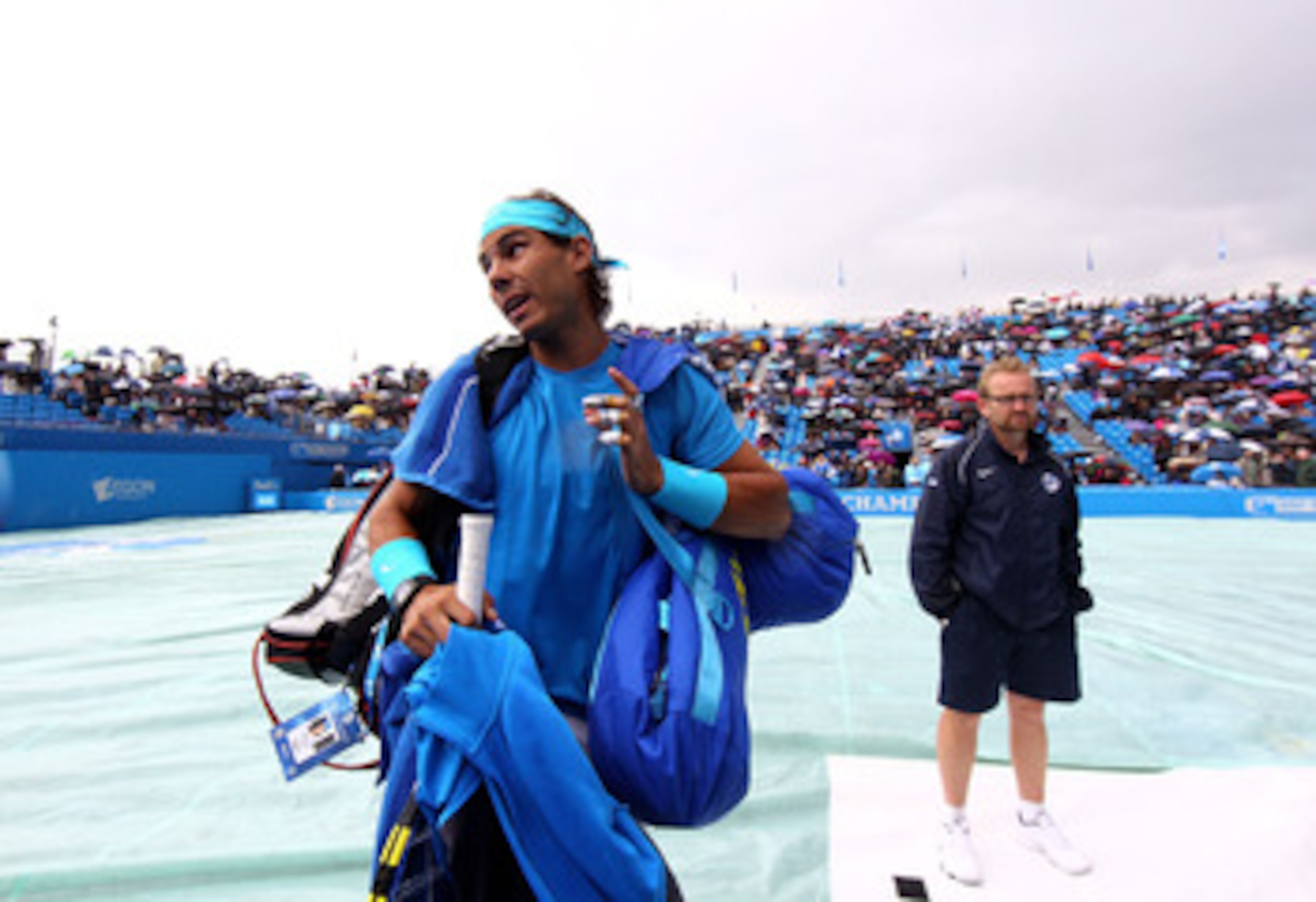 LONDON, ENGLAND - JUNE 10:  Rafael Nadal of Spain walks off court as rain delays play during his Men's Singles quarter final match against Jo-Wilfred Tsonga of France on day five of the AEGON Championships at Queens Club on June 10, 2011 in London, Englan