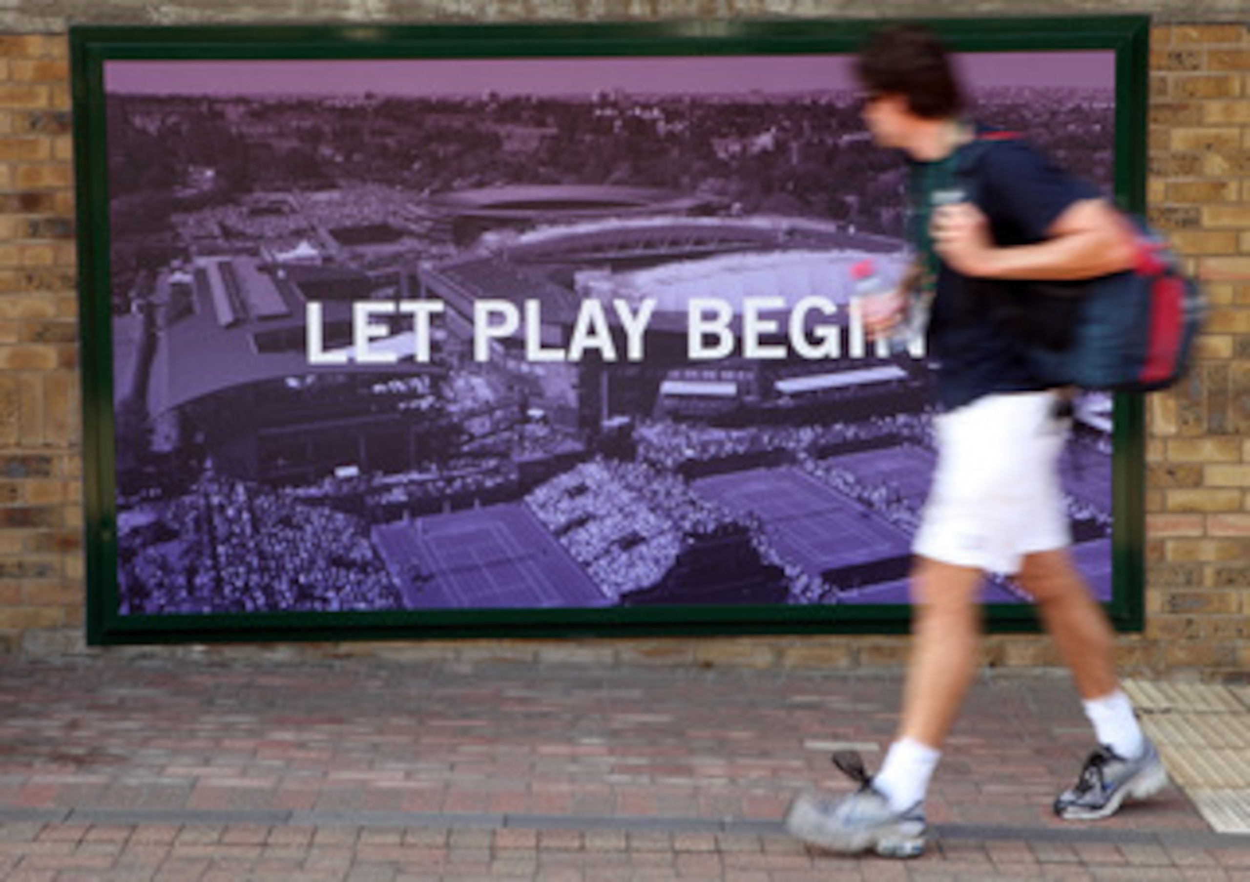 LONDON, ENGLAND - JUNE 28:  A visitor walks past a poster on Day Seven of the Wimbledon Lawn Tennis Championships at the All England Lawn Tennis and Croquet Club on June 28, 2010 in London, England.  (Photo by Oli Scarff/Getty Images)