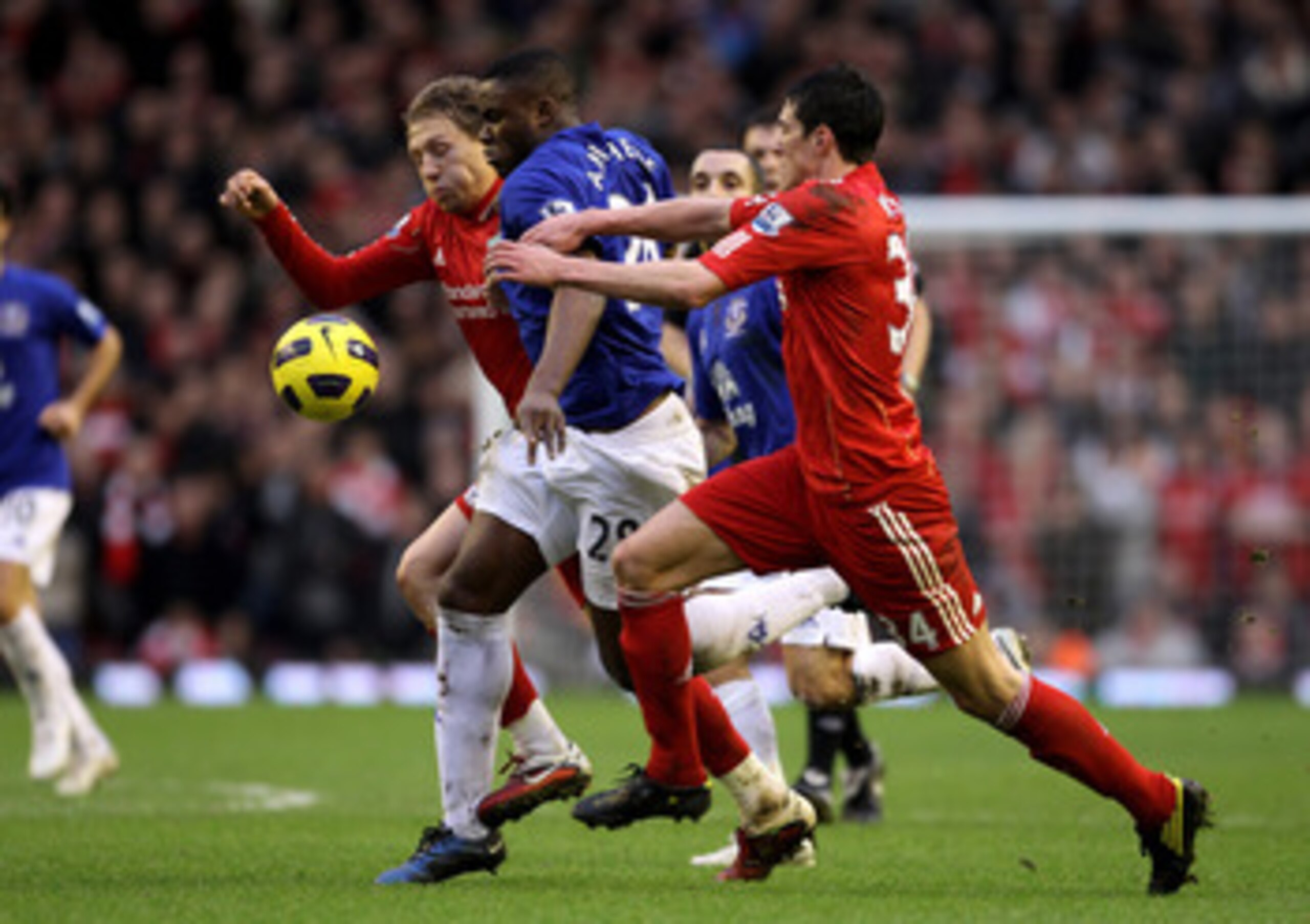 LIVERPOOL, ENGLAND - JANUARY 16:  Lucas (L) and Martin Kelly of Liverpool battle for the ball with Victor Anichebe of Everton during the Barclays Premier League match between Liverpool and Everton at Anfield on January 16, 2011 in Liverpool, England. (Pho