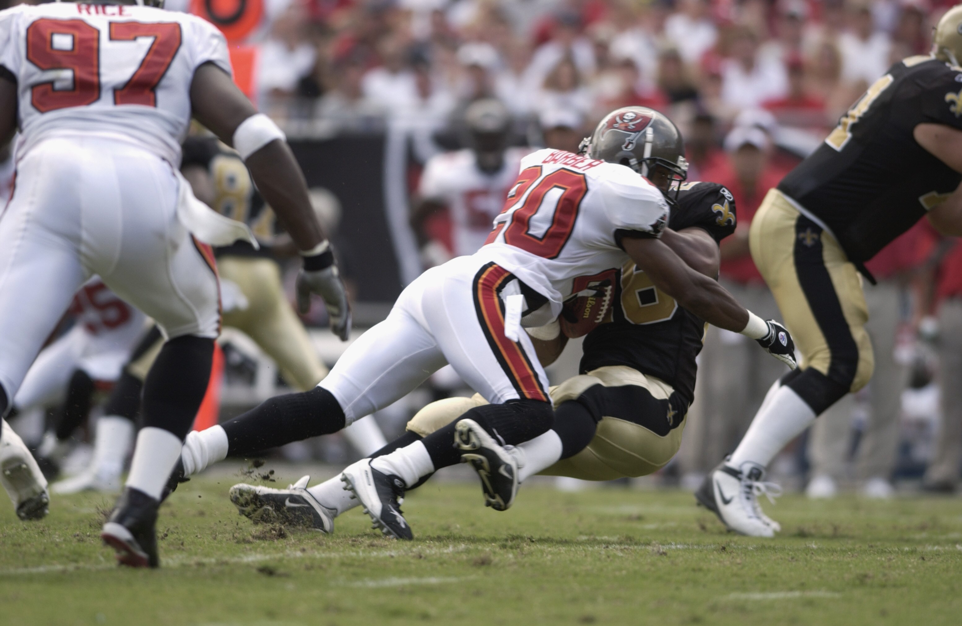 TAMPA BAY, FL - SEPTEMBER 8:  Cornerback Ronde Barber #20 of the Tampa Bay Buccaneers applies a big hit to an unidentified New Orleans Saint during the first quarter on September 8, 2002 at Raymond James Stadium in Tampa, Florida.  The Saints defeated the