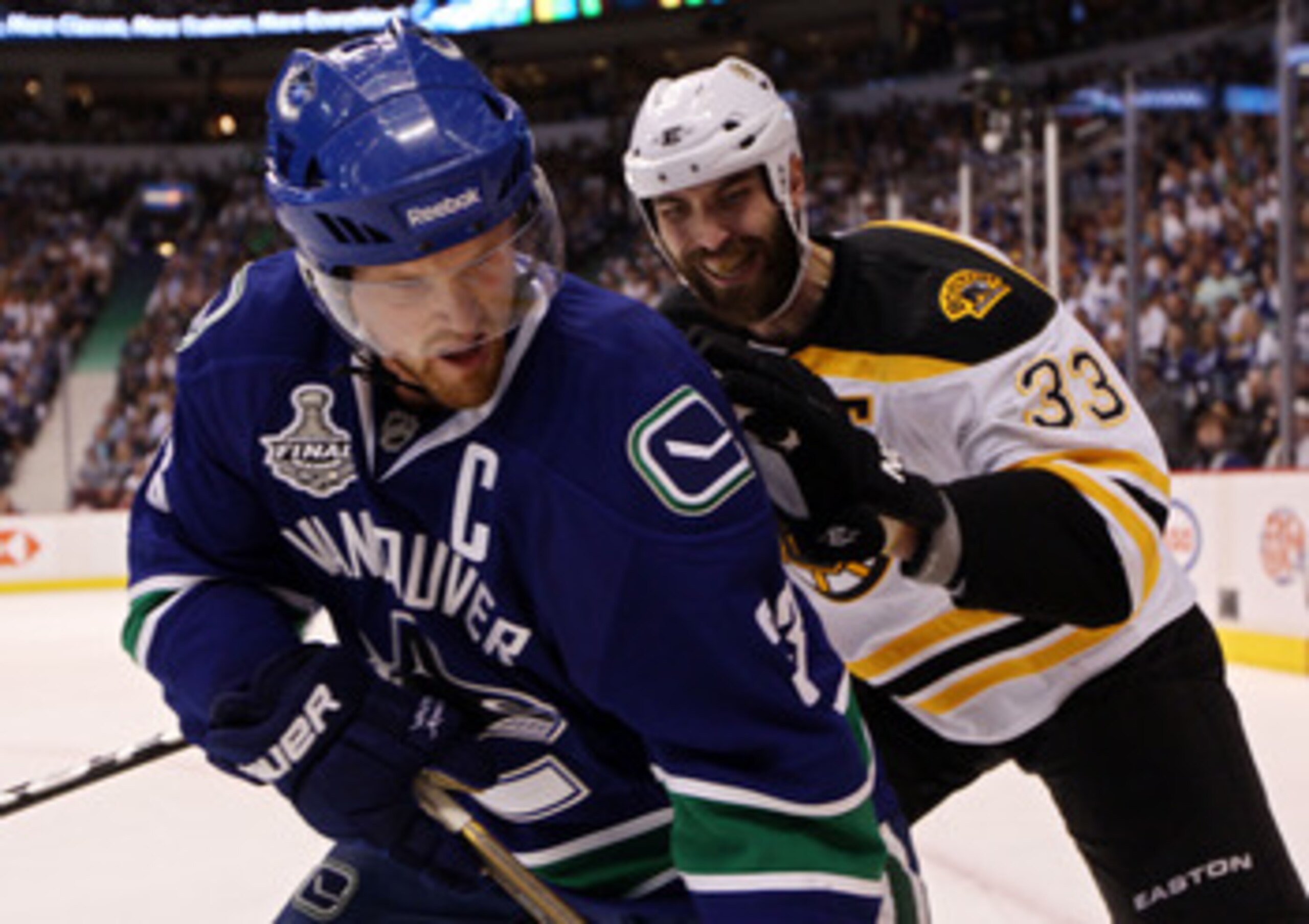 VANCOUVER, BC - JUNE 10:  Henrik Sedin #33 of the Vancouver Canucks handles the puck against Zdeno Chara #33 of the Boston Bruins during Game Five of the 2011 NHL Stanley Cup Final at Rogers Arena on June 10, 2011 in Vancouver, British Columbia, Canada.