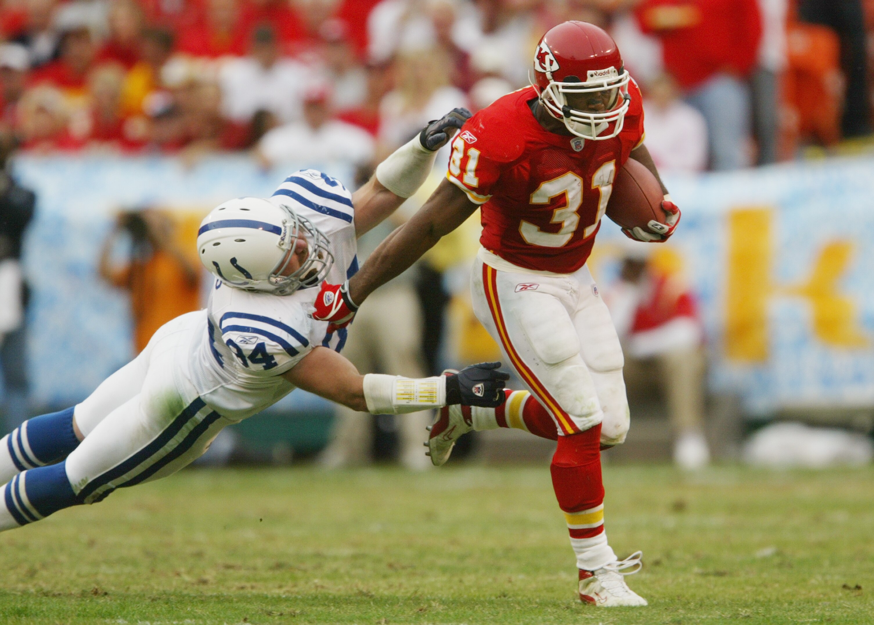 KANSAS CITY, MO - OCTOBER 31:  Priest Holmes #31 of the Kansas City Chiefs sheds a tackle attempt by Rob Morris #94 of the Indianapolis Colts during the game at Arrowhead Stadium on October 31, 2004 in Kansas City, Missouri. The Chiefs defeated the Colts