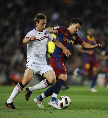 BARCELONA, SPAIN - APRIL 23:  David Villa of FC Barcelona fights for the ball against Nacho Monreal of CA Osasuna during the La Liga match between Barcelona and CA Osasuna at Camp Nou Stadium on April 23, 2011 in Barcelona, Spain.  (Photo by David Ramos/G