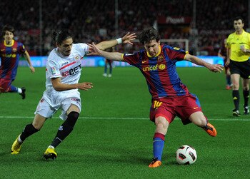SEVILLE, SPAIN - MARCH 13:  Lionel Messi (R) of Barcelona fights for the ball with Jose Caceres of Sevilla during the la Liga match between Sevilla and Barcelona at Estadio Ramon Sanchez Pizjuan on March 13, 2011 in Seville, Spain.  (Photo by Jasper Juine