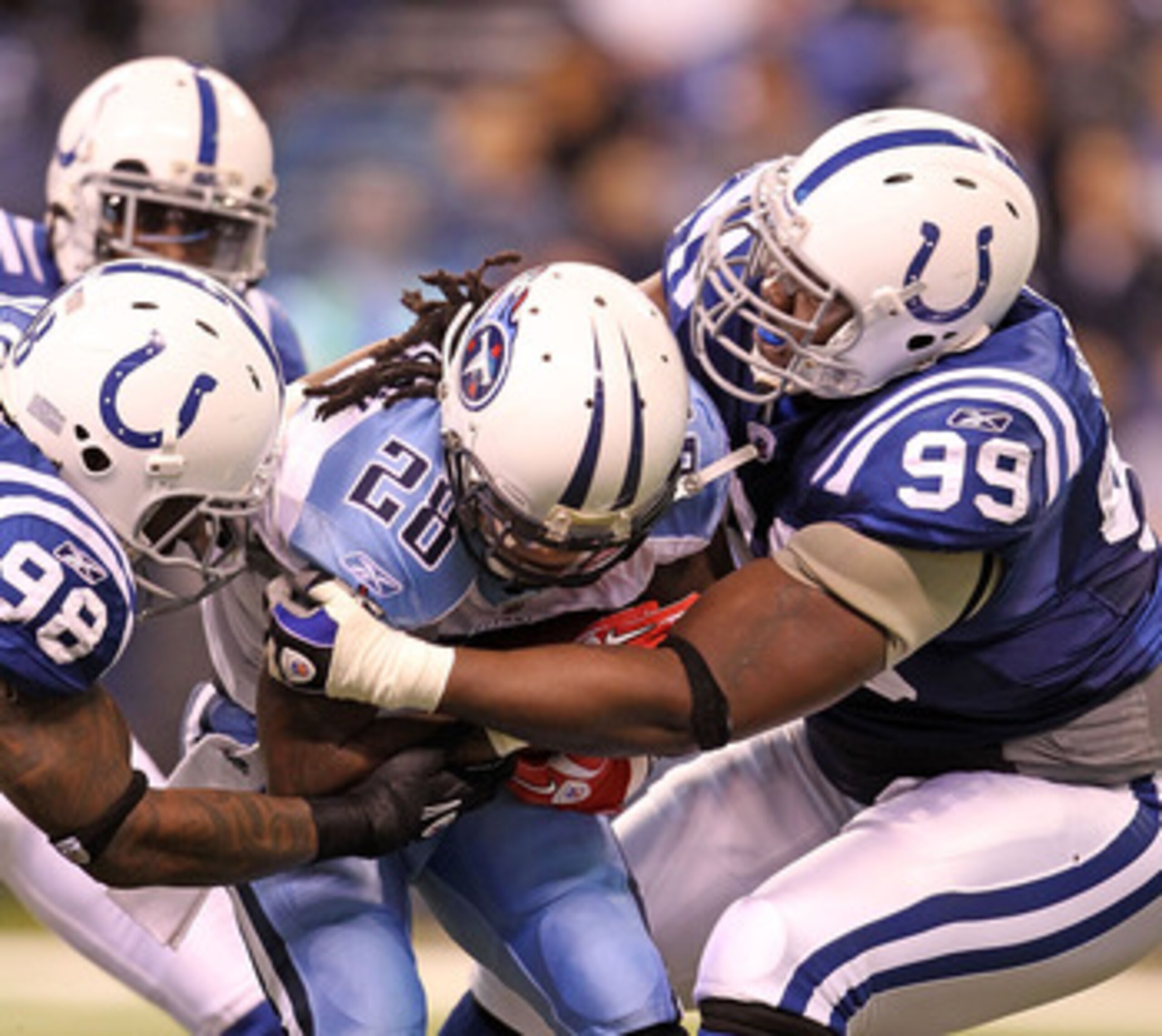INDIANAPOLIS - JANUARY 02:  Chris Johnson #28 of the Tennessee Titans is tackled by Robert Mathis #98 and Antonio Johnson #99 of the Indianapolis Colts at Lucas Oil Stadium on January 2, 2011 in Indianapolis, Indiana.  the Colts won 23-20.  (Photo by Andy