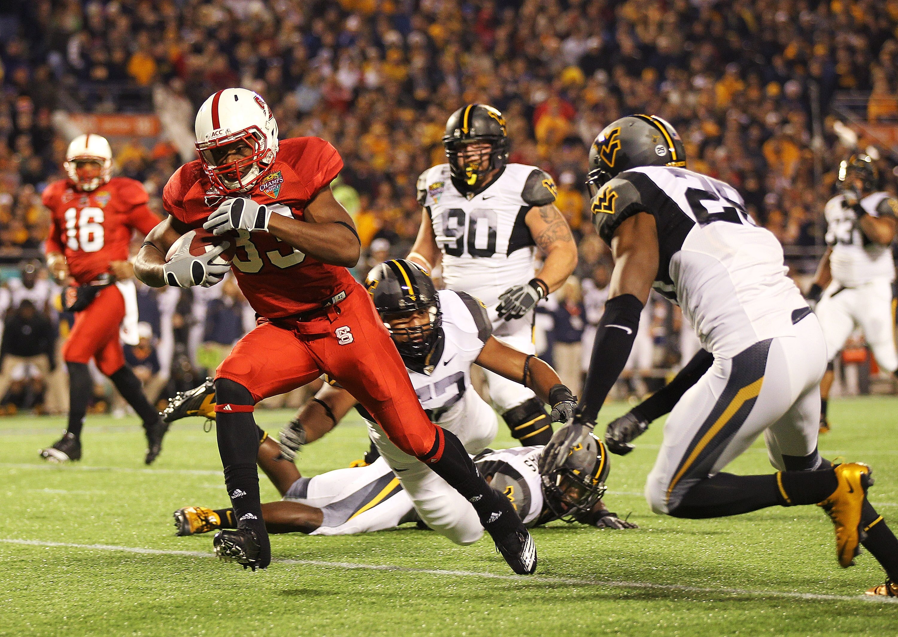ORLANDO, FL - DECEMBER 28:  Mustafa Greene #33 of the North Carolina State Wolfpack scores a touchdown during the Champs Sports Bowl against the West Virginia Mountineers at Florida Citrus Bowl Stadium on December 28, 2010 in Orlando, Florida.  (Photo by