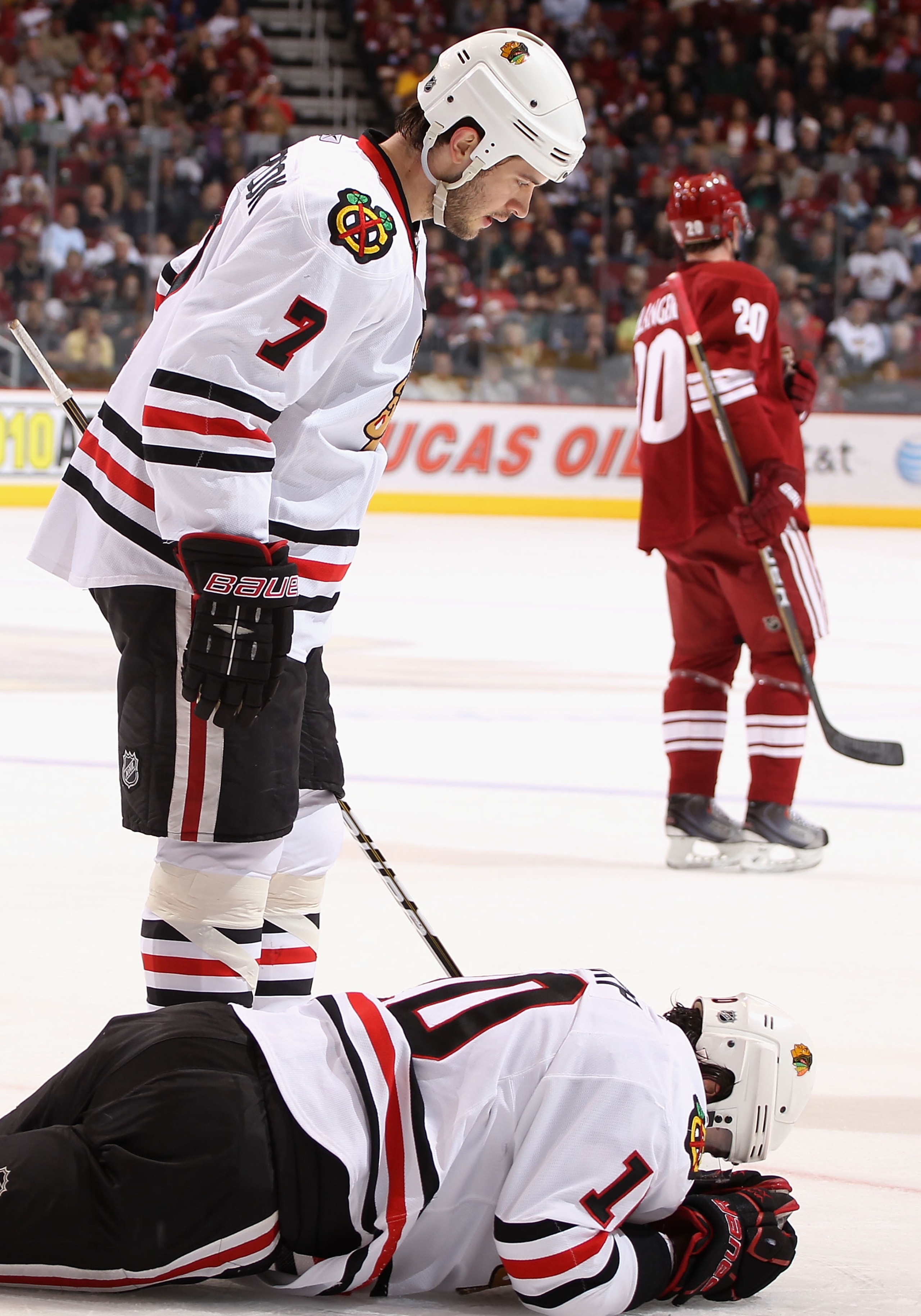 GLENDALE, AZ - MARCH 20:  Patrick Sharp #10 of the Chicago Blackhawks lays on the ice after an injury as Brent Seabrook #7 looks down during the first period of the NHL game against the Phoenix Coyotes at Jobing.com Arena on March 20, 2011 in Glendale, Ar
