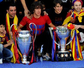 BARCELONA, SPAIN - MAY 29:  FC Barcelona players pose with the La Liga Tropy and the UEFA Champions League trophy during the celebrations after winning the UEFA Champions League Final against Manchester United at Camp Nou Stadium on May 29, 2011 in Barcel