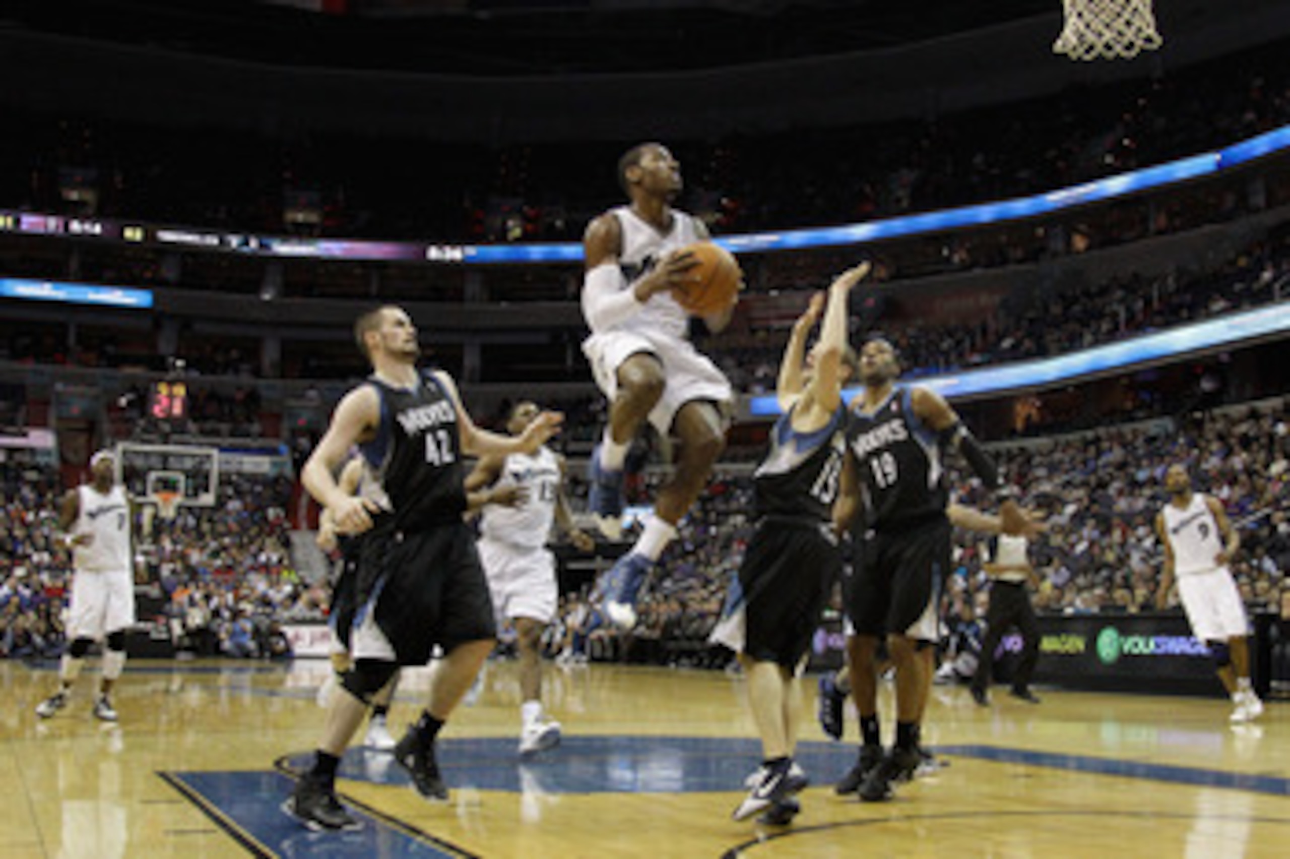 WASHINGTON, DC - MARCH 05:  John Wall #2 of the Washington Wizards puts up a shot while being defended by Kevin Love #42 and Luke Ridnour #13 of the Minnesota Timberwolves at the Verizon Center on March 5, 2011 in Washington, DC. NOTE TO USER: User expres