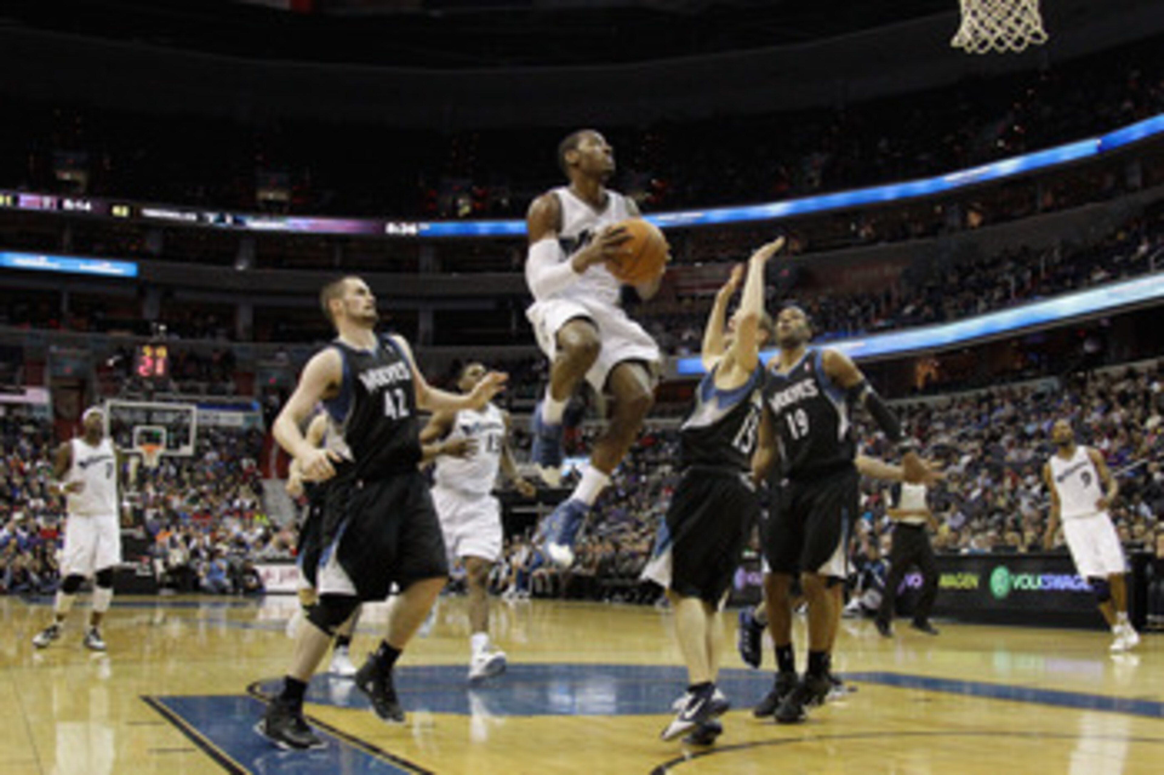 WASHINGTON, DC - MARCH 05:  John Wall #2 of the Washington Wizards puts up a shot while being defended by Kevin Love #42 and Luke Ridnour #13 of the Minnesota Timberwolves at the Verizon Center on March 5, 2011 in Washington, DC. NOTE TO USER: User expres