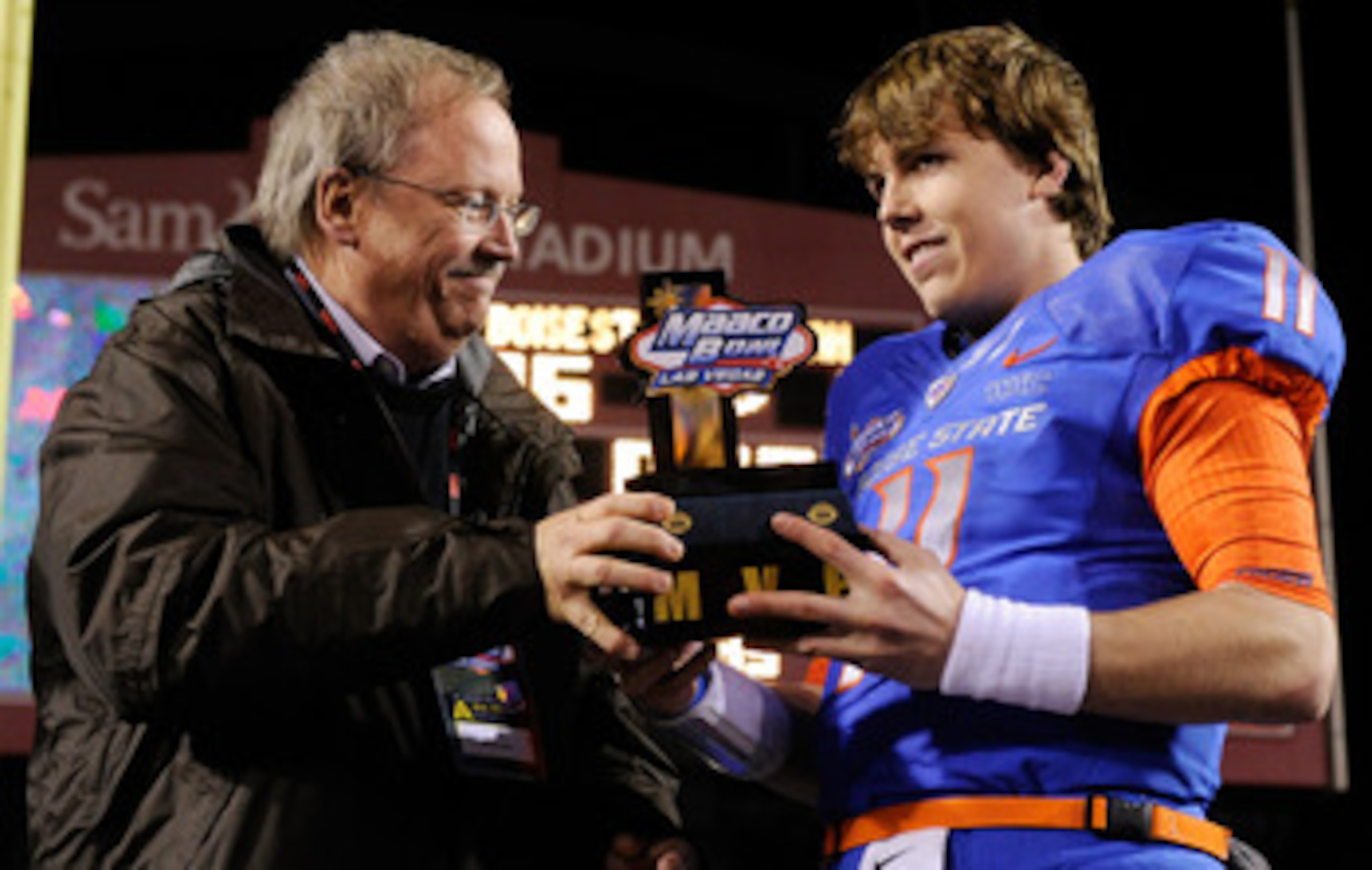 LAS VEGAS, NV - DECEMBER 22:  MAACO President Dave Lapps (L) gives the most valuable player trophy to quarterback Kellen Moore #11 of the Boise State Broncos after the team's 26-3 victory over the Utah Utes in the MAACO Bowl Las Vegas at Sam Boyd Stadium