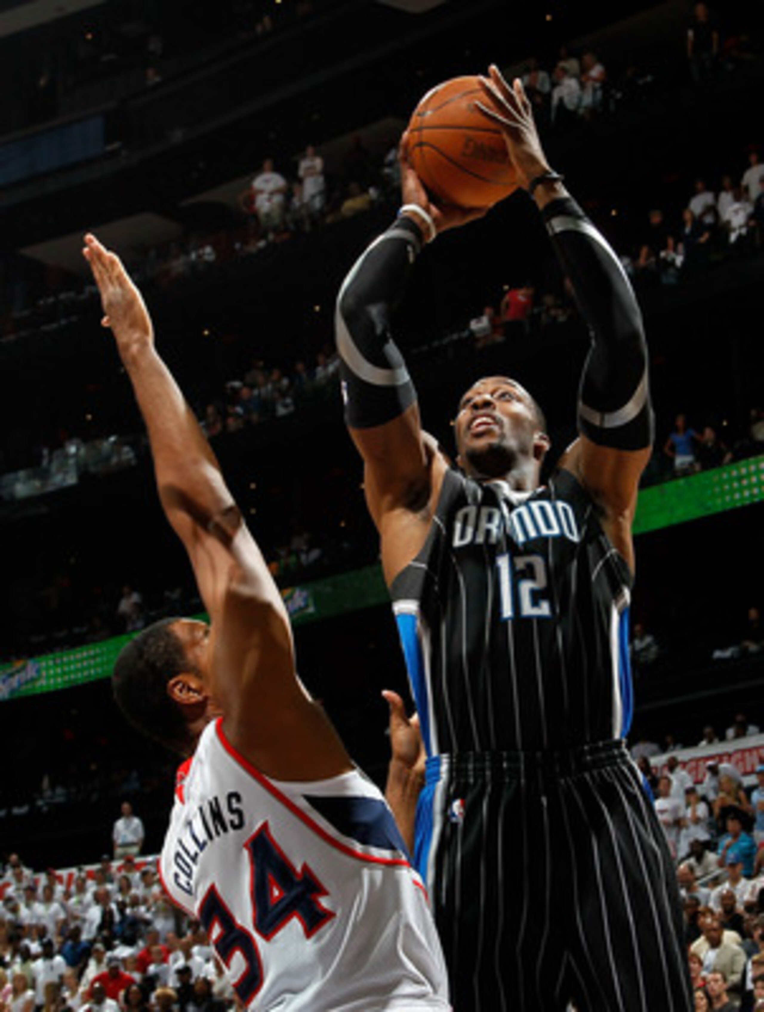 ATLANTA, GA - APRIL 24:  Dwight Howard #12 of the Orlando Magic shoots over Jason Collins #34 of the Atlanta Hawks during Game Four of the Eastern Conference Quarterfinals in the 2011 NBA Playoffs at Philips Arena on April 24, 2011 in Atlanta, Georgia.  N