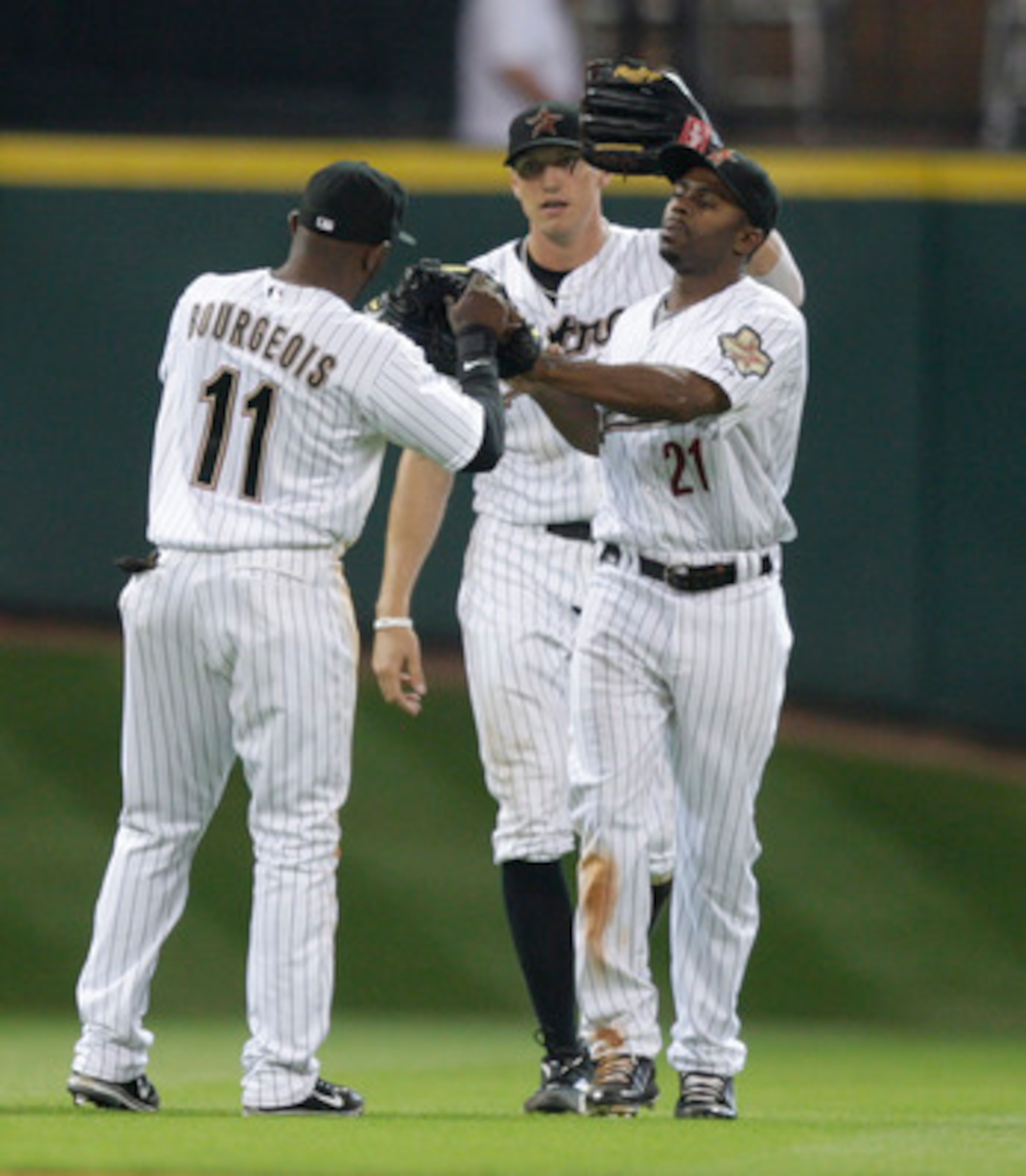 HOUSTON - APRIL 14:  Michael Bourn #21, Jason Bourgeois #11 and Hunter Pence #9 celebrate after the final out against the  San Diego Padres at Minute Maid Park on April 14, 2011 in Houston, Texas.  (Photo by Bob Levey/Getty Images)