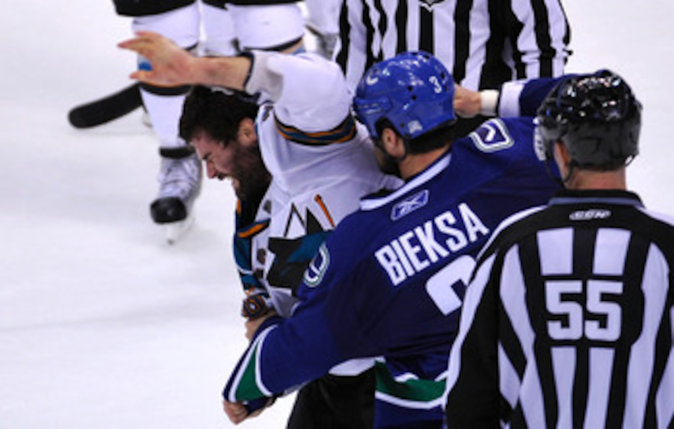 VANCOUVER, CANADA - MAY 18:  Patrick Marleau #12 of the San Jose Sharks tries to defend himself during a fight as Kevin Bieksa #3 of the Vancouver Canucks prepares to throw a punch in the second period in Game Two of the Western Conference Finals during t