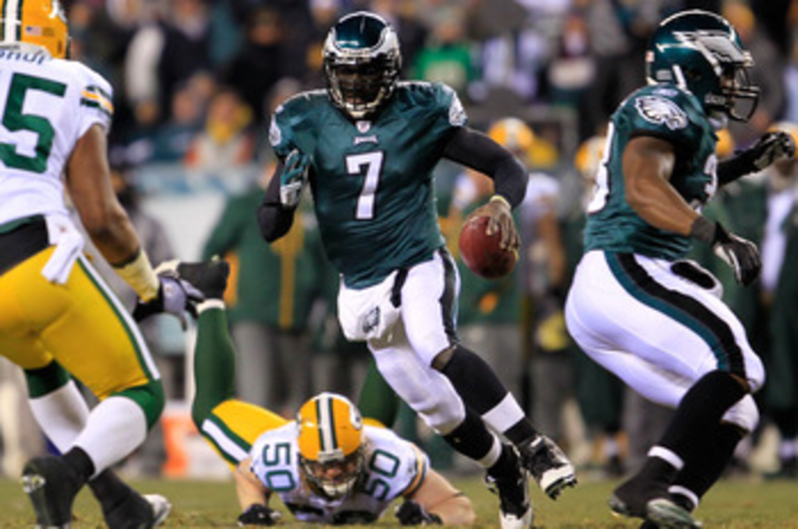 PHILADELPHIA, PA - JANUARY 09:  Michael Vick #7 of the Philadelphia Eagles scrambles against A.J. Hawk #50 and Desmond Bishop #55 of the Green Bay Packers during the 2011 NFC wild card playoff game at Lincoln Financial Field on January 9, 2011 in Philadel