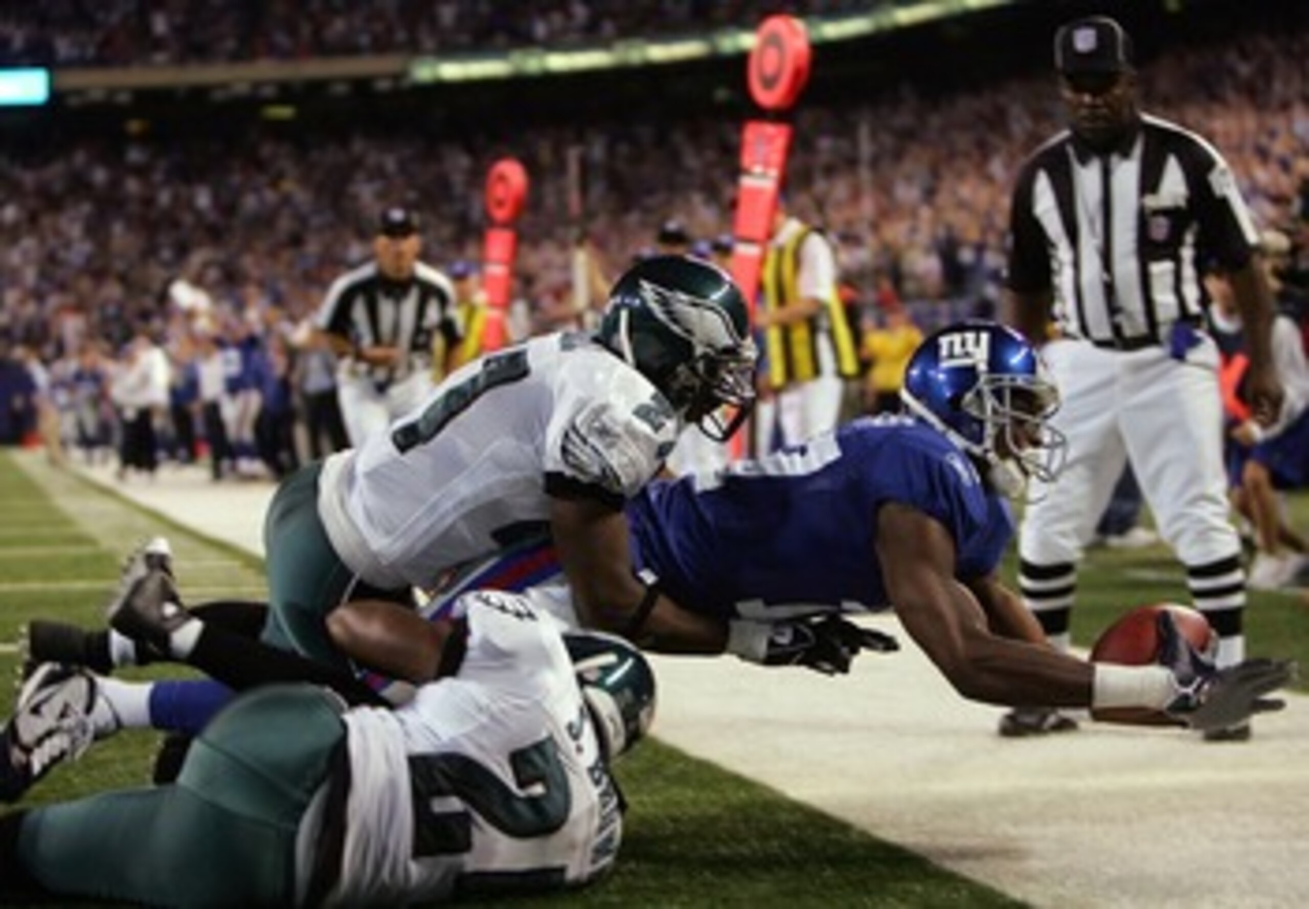 EAST RUTHERFORD, NJ - SEPTEMBER 30:  Plaxico Burress #17 of the New York Giants goes with a touchdown catch over Sheldon Brown #24 and Quintin Mikell  #27 of the Philadelphia Eagles at Giants Stadium on September 30, 2007 in East Rutherford, New Jersey.  