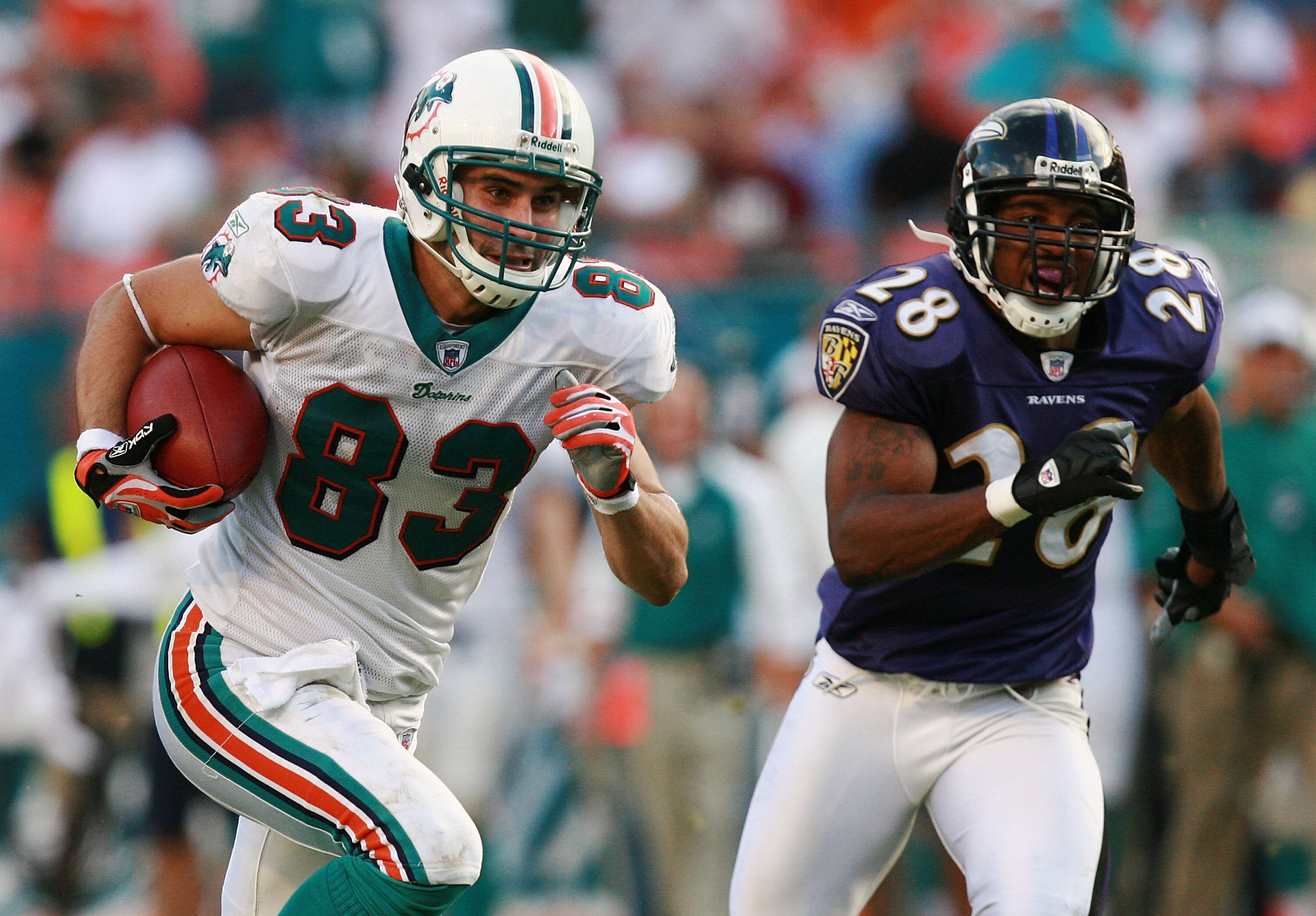MIAMI - DECEMBER 16:  Wide receiver Greg Camarillo #83 of the Miami Dolphins breaks away from defensive back Jamaine Winborne #28 of the Baltimore Ravens for the game winning touchdown in overtime at Dolphin Stadium on December 16, 2007 in Miami, Florida.