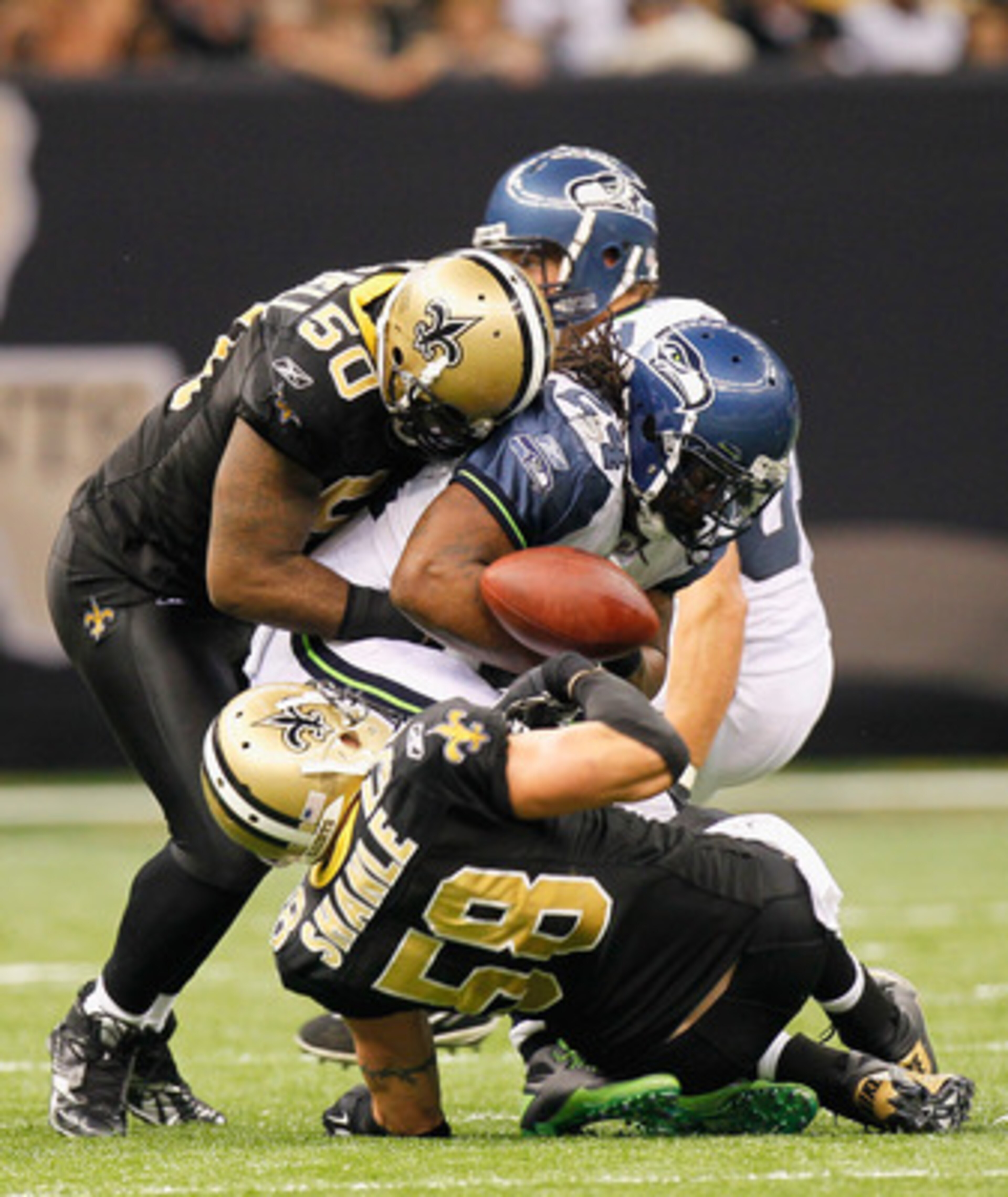 NEW ORLEANS - NOVEMBER 21:  Marvin Mitchell #50 of the New Orleans Saints makes a tackle on Marshawn Lynch #24 of the Seattle Seahawks as Scott Shanle #58 forces a fumble at Louisiana Superdome on November 21, 2010 in New Orleans, Louisiana.  (Photo by Ke